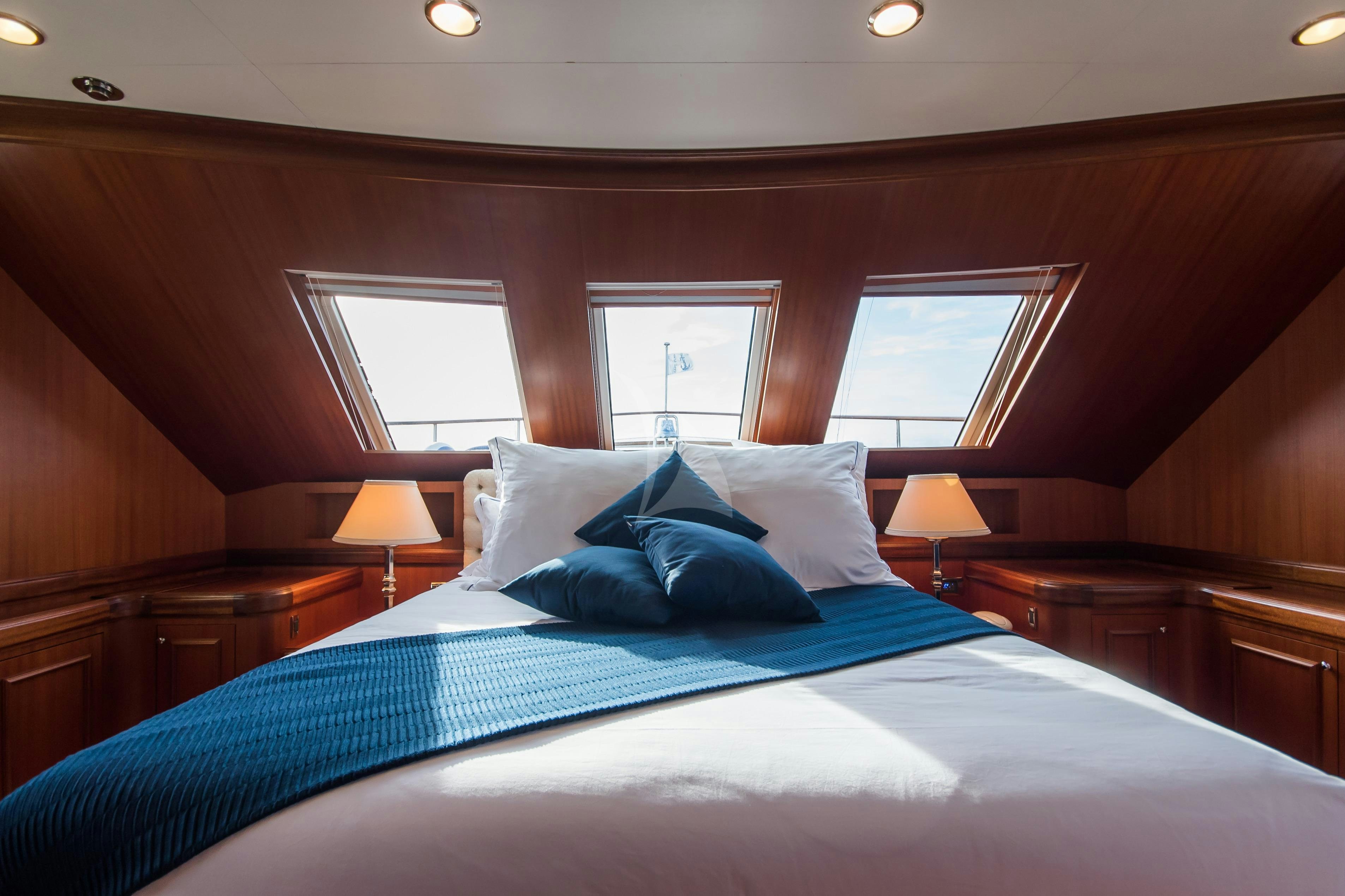 a bed with blue sheets aboard ELENI Yacht for Charter