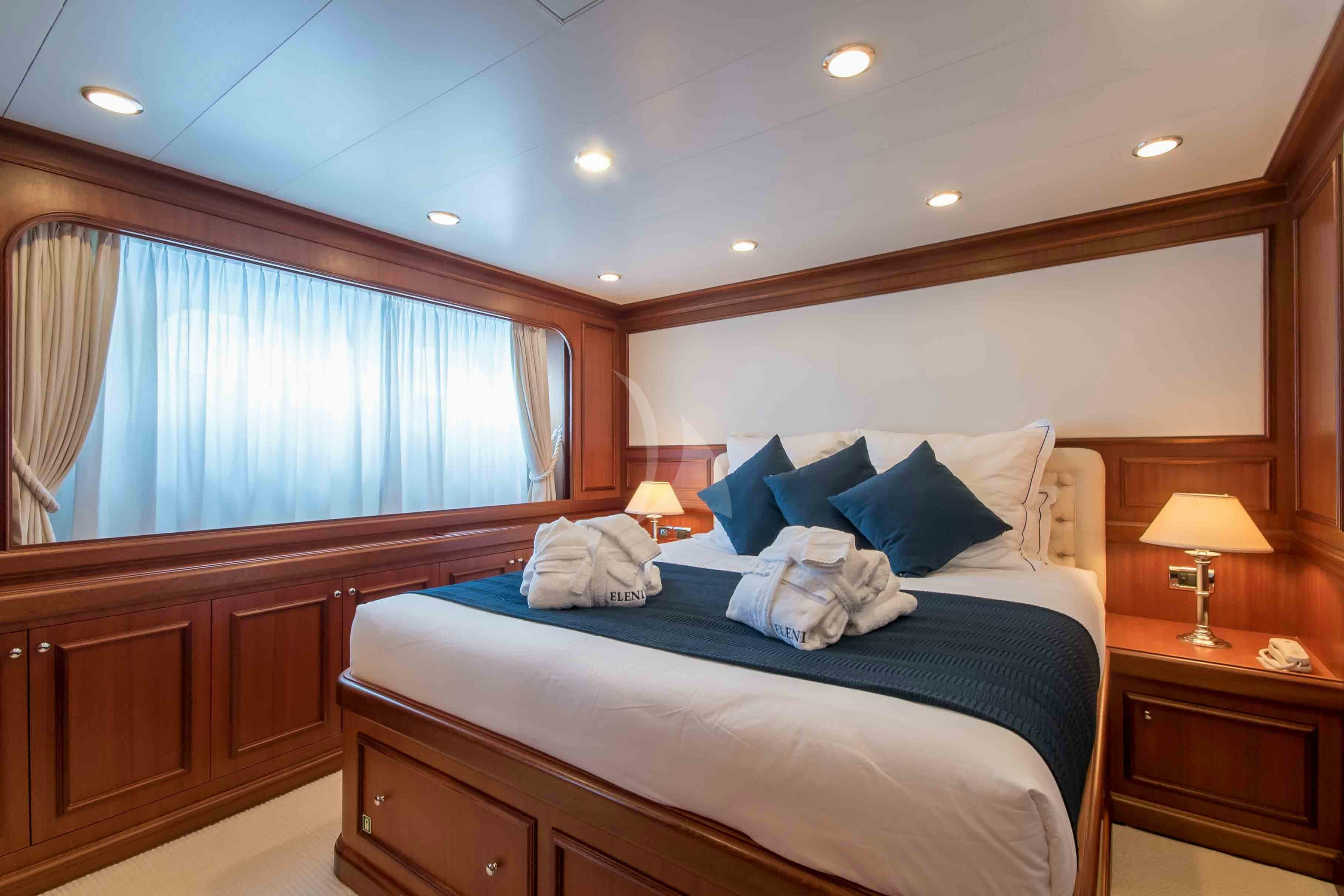 a bed with a blue pillow aboard ELENI Yacht for Charter