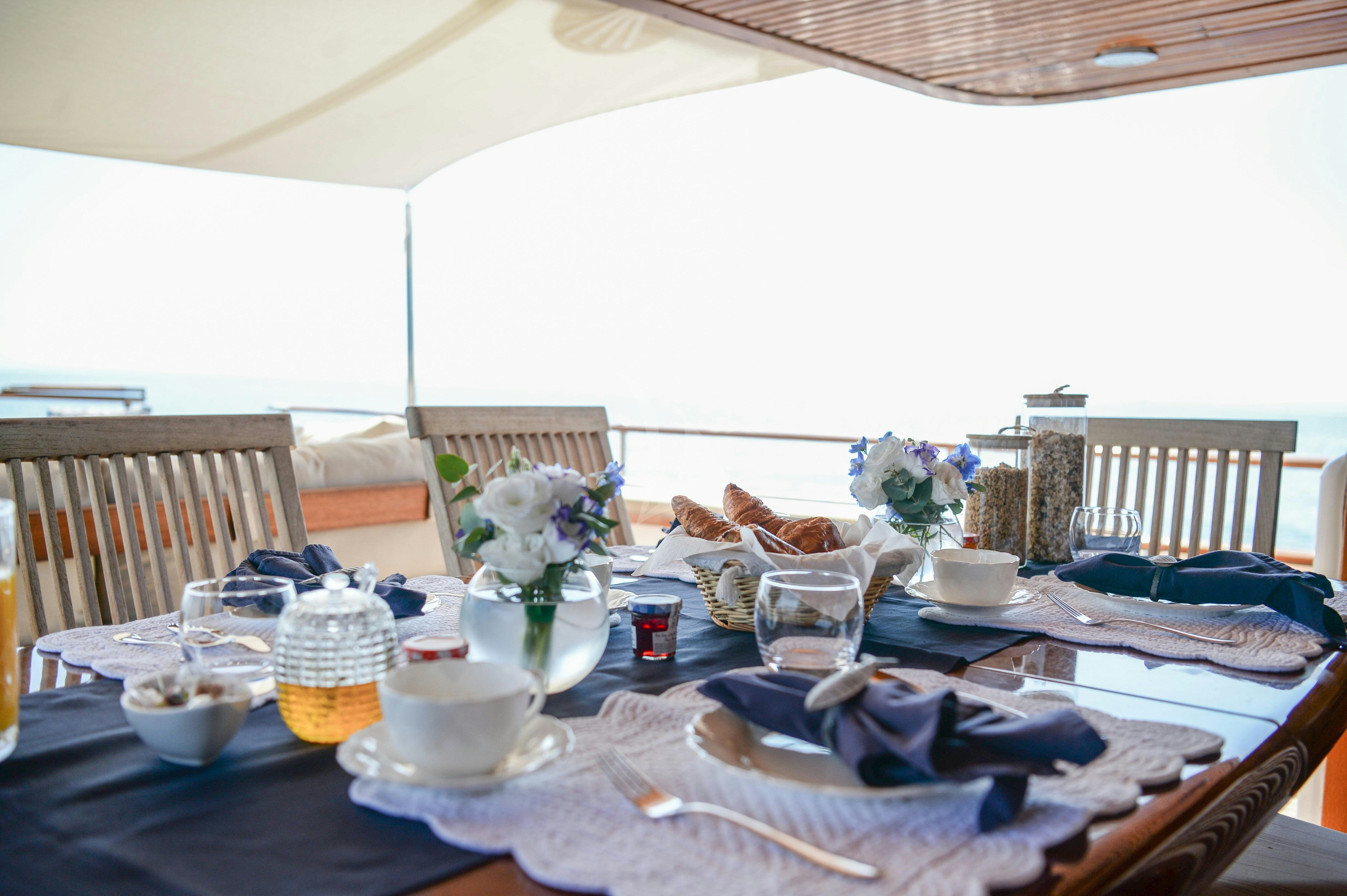 a table with a vase of flowers and a plate of food aboard ATLANTIC ENDEAVOUR Yacht for Charter