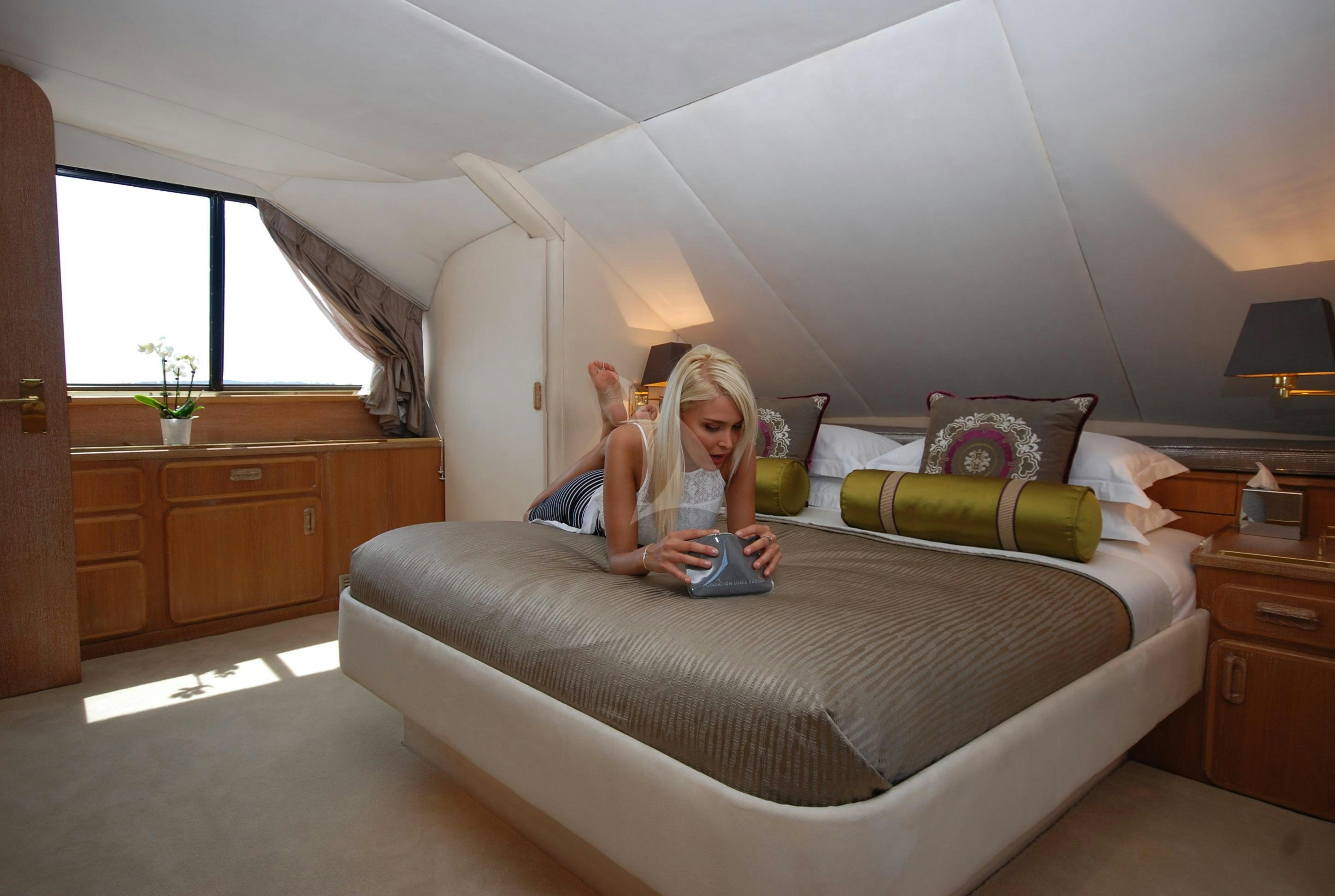 a person sitting on a bed aboard ATLANTIC ENDEAVOUR Yacht for Charter