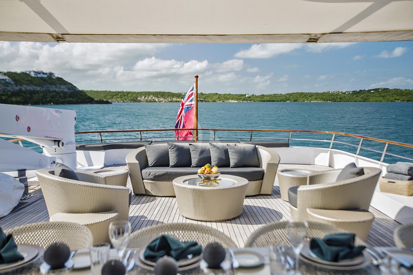 a table with chairs and a flag on it aboard SHAKE N' BAKE TBD Yacht for Charter