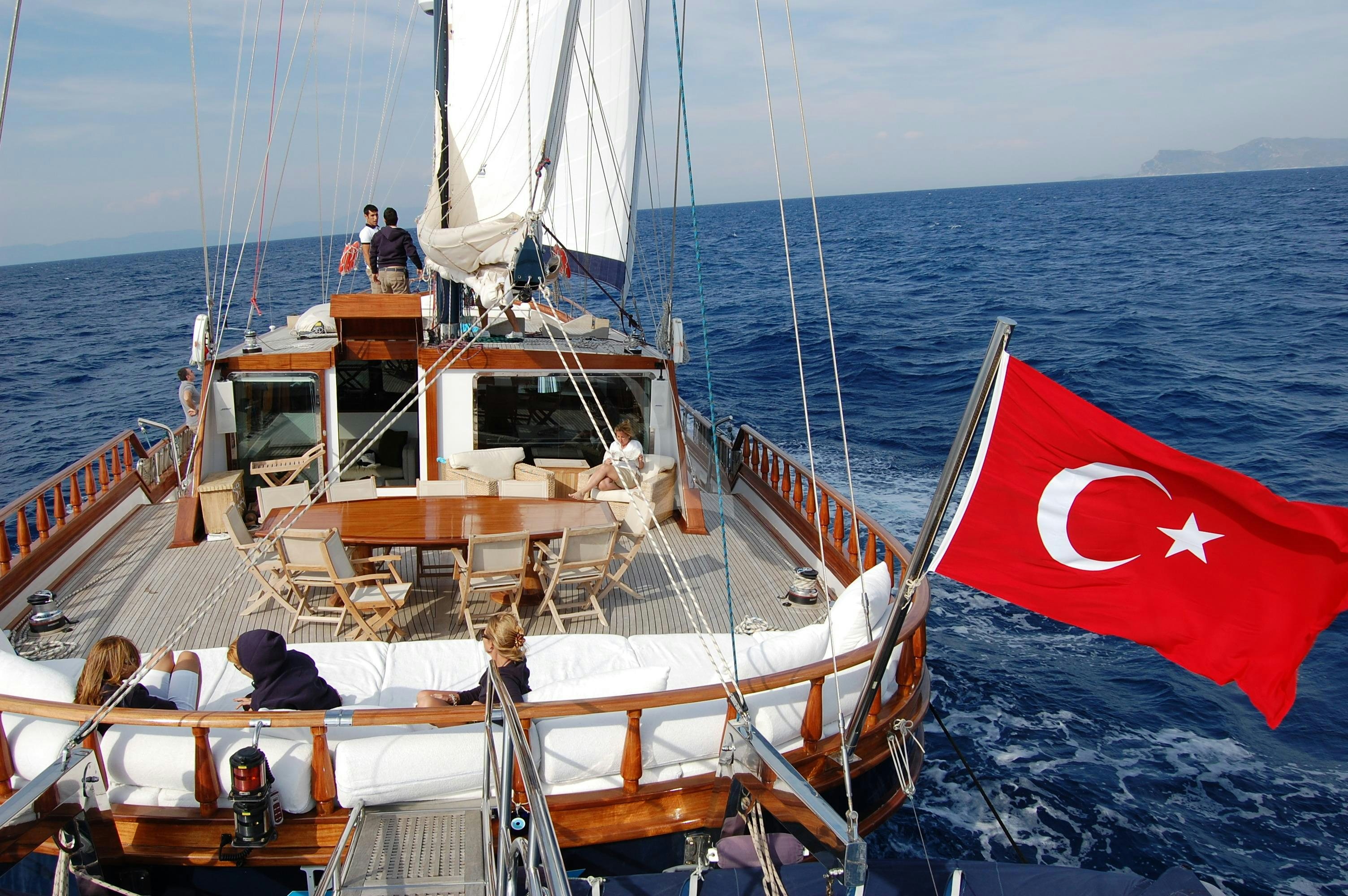 a boat with a flag on the front aboard PAPA JOE Yacht for Charter