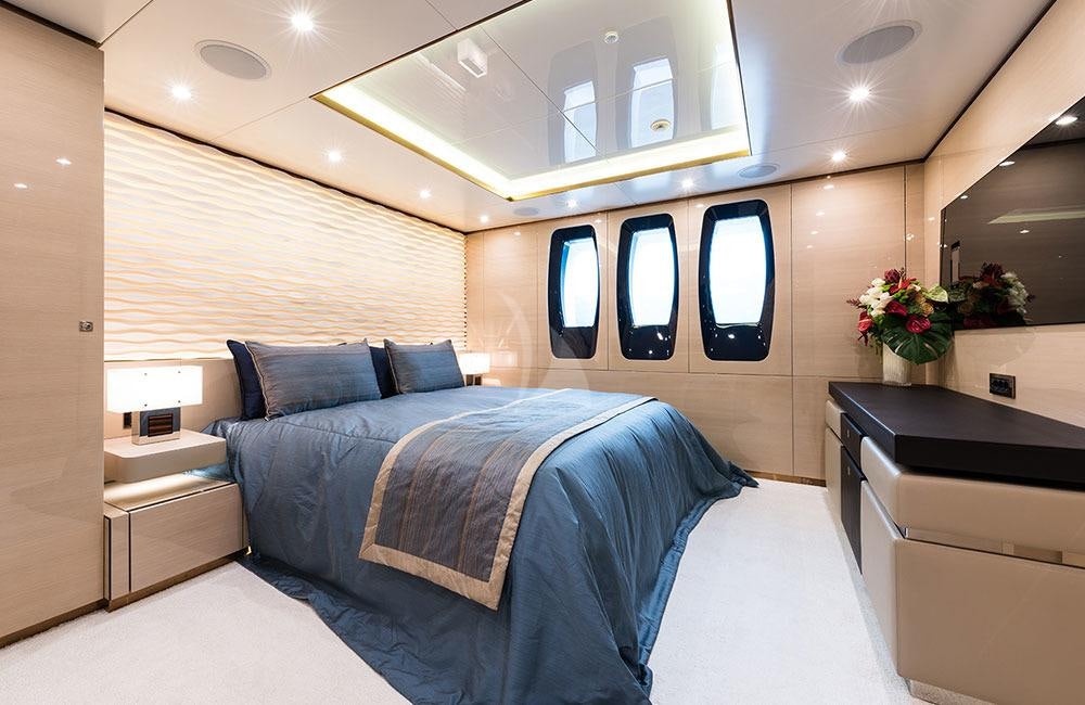 a room with a bed and a desk aboard ALMAX Yacht for Charter
