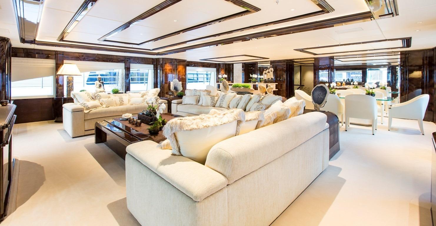 a living room with a large white couch and a large window aboard ILLUSION V Yacht for Charter