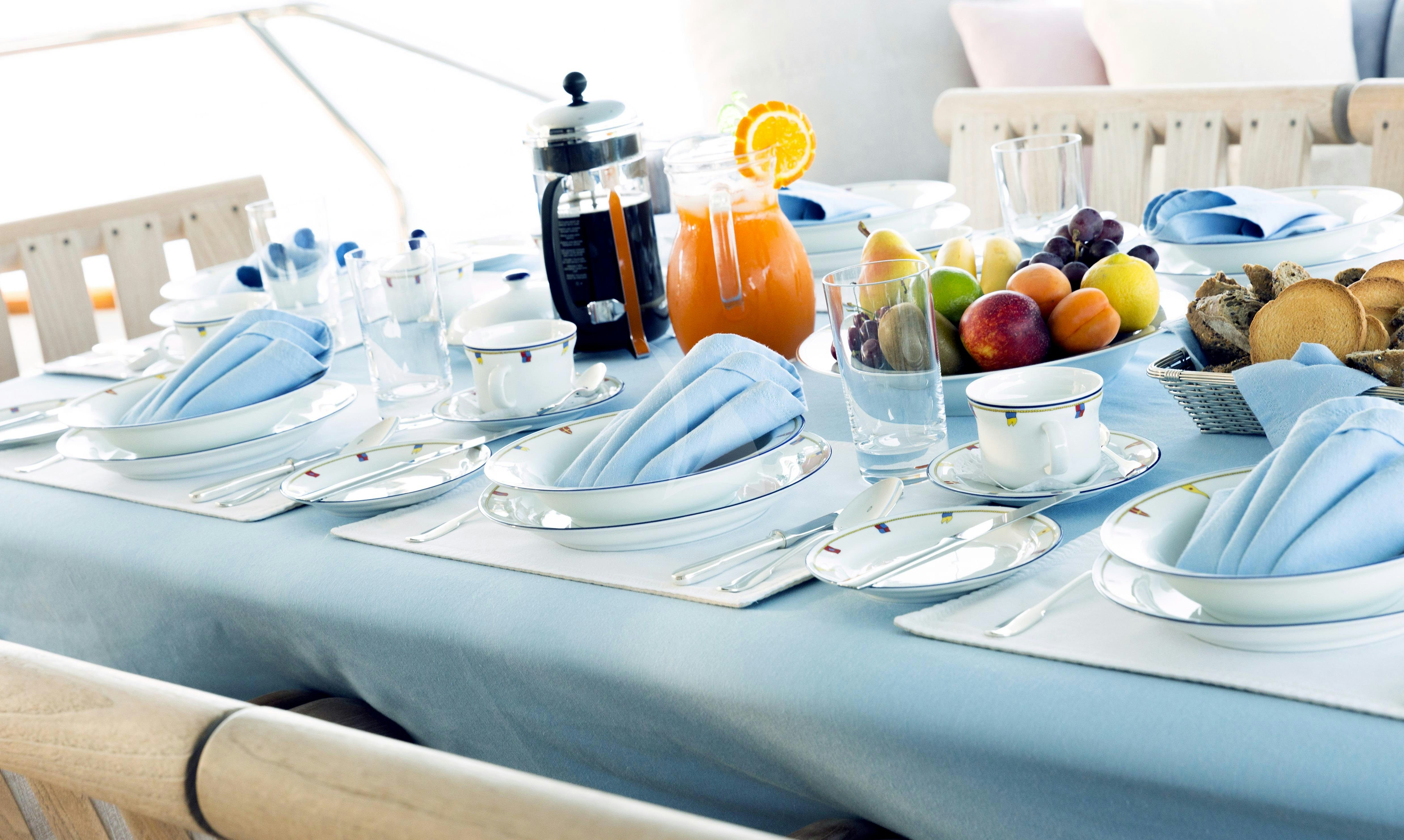 a table with plates and glasses aboard CLARITY Yacht for Charter