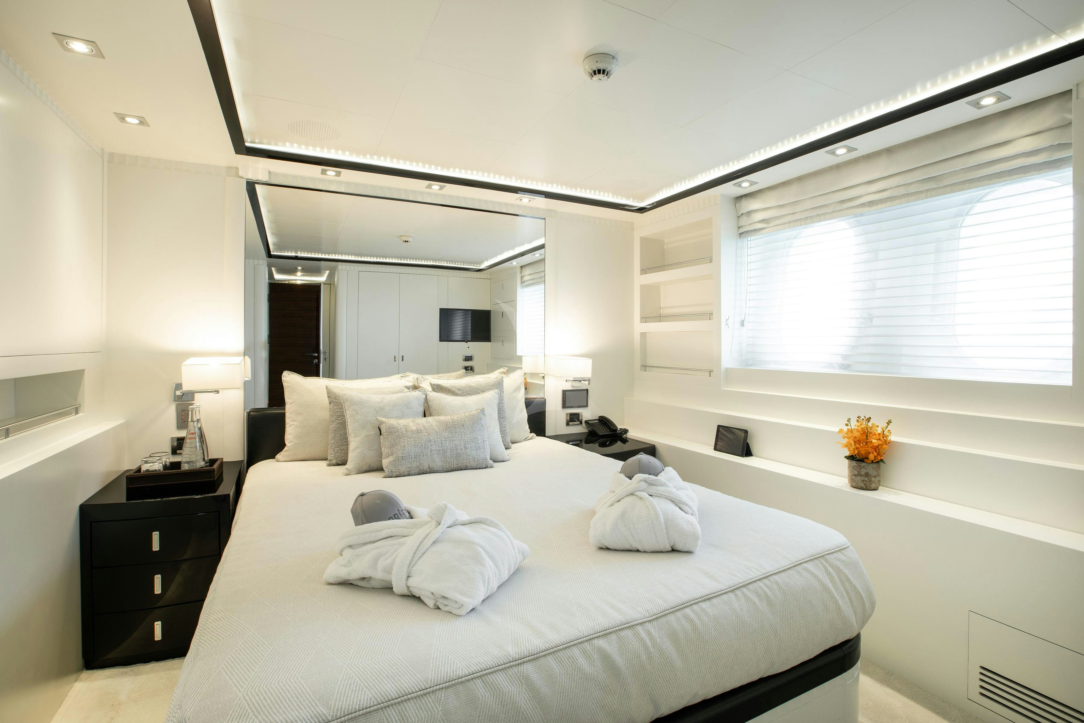 a large white bedroom with a large bed and a window aboard VERTIGO Yacht for Charter