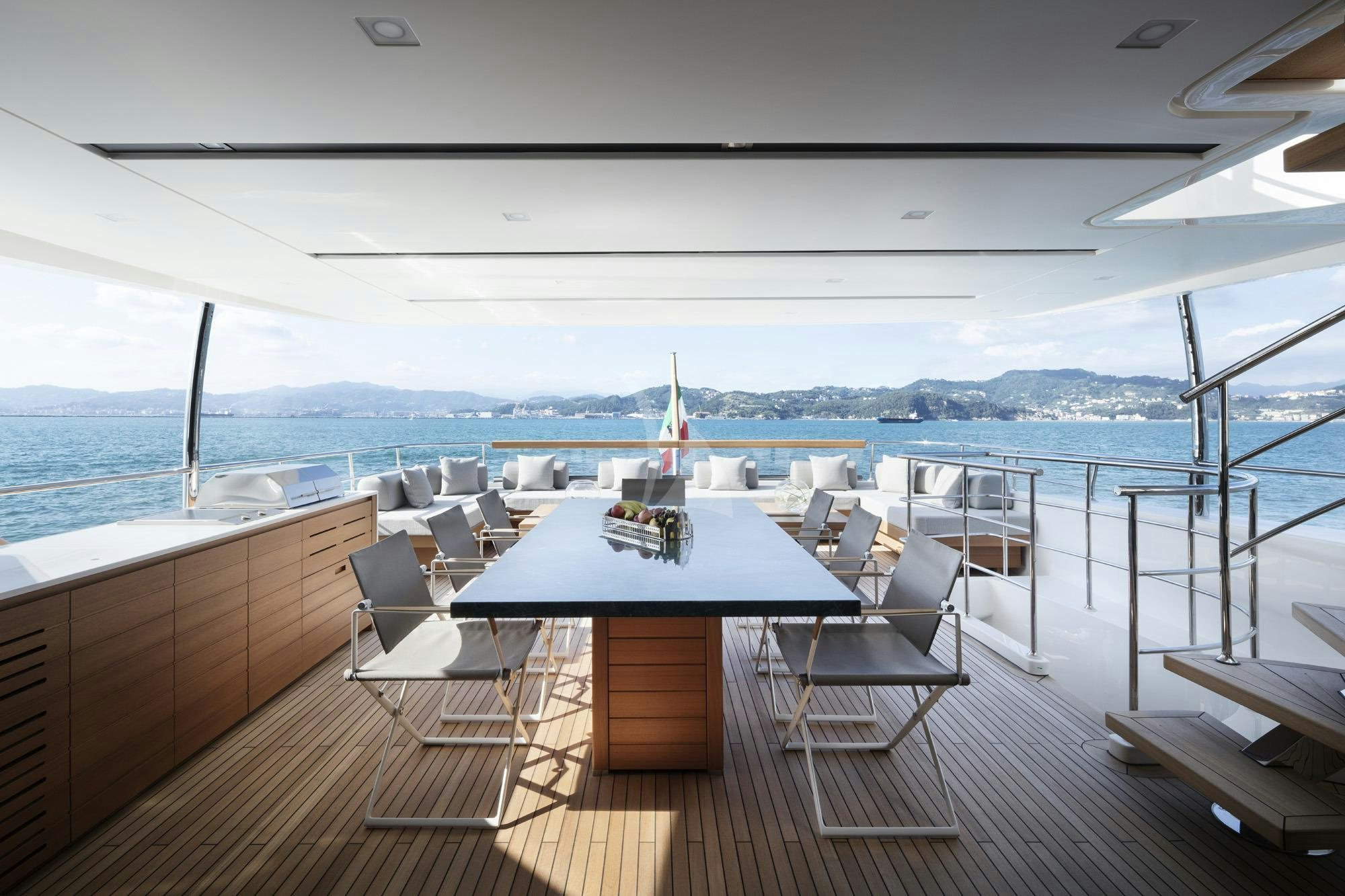a table and chairs on a deck overlooking a body of water aboard NAMASTE Yacht for Charter