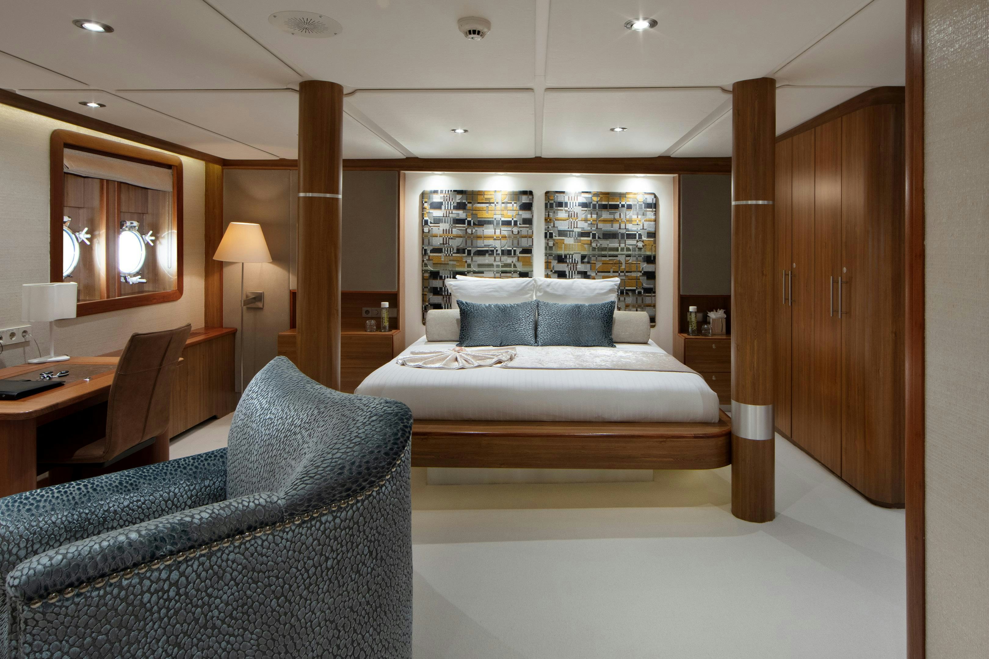 a room with a bed and a chair aboard SHERAKHAN Yacht for Charter