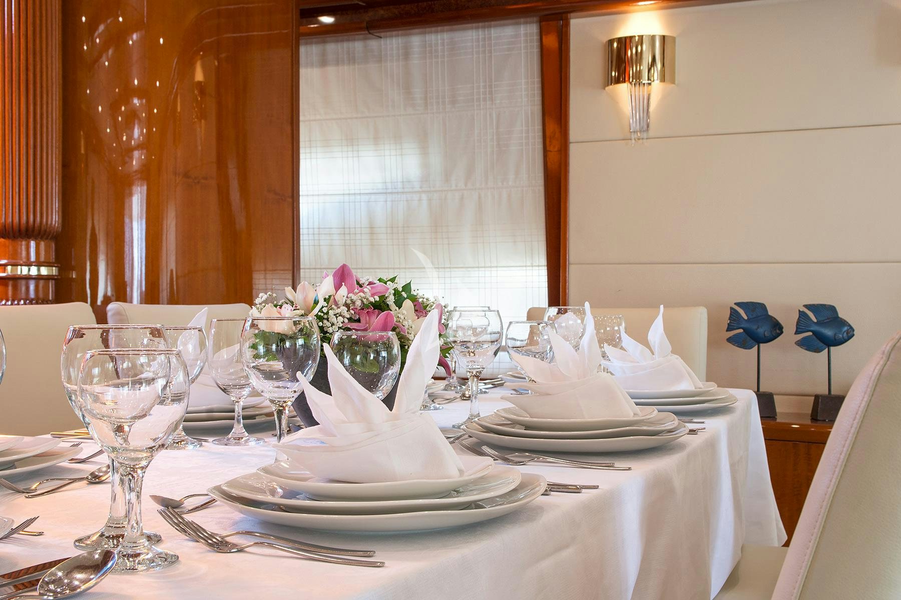 a table set with place settings aboard DREAM B Yacht for Charter