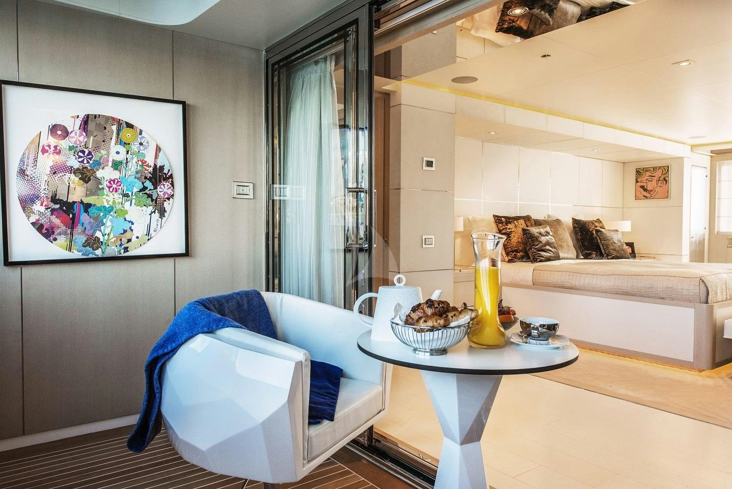 a living room with a blue chair and a white table aboard LIGHT HOLIC Yacht for Charter