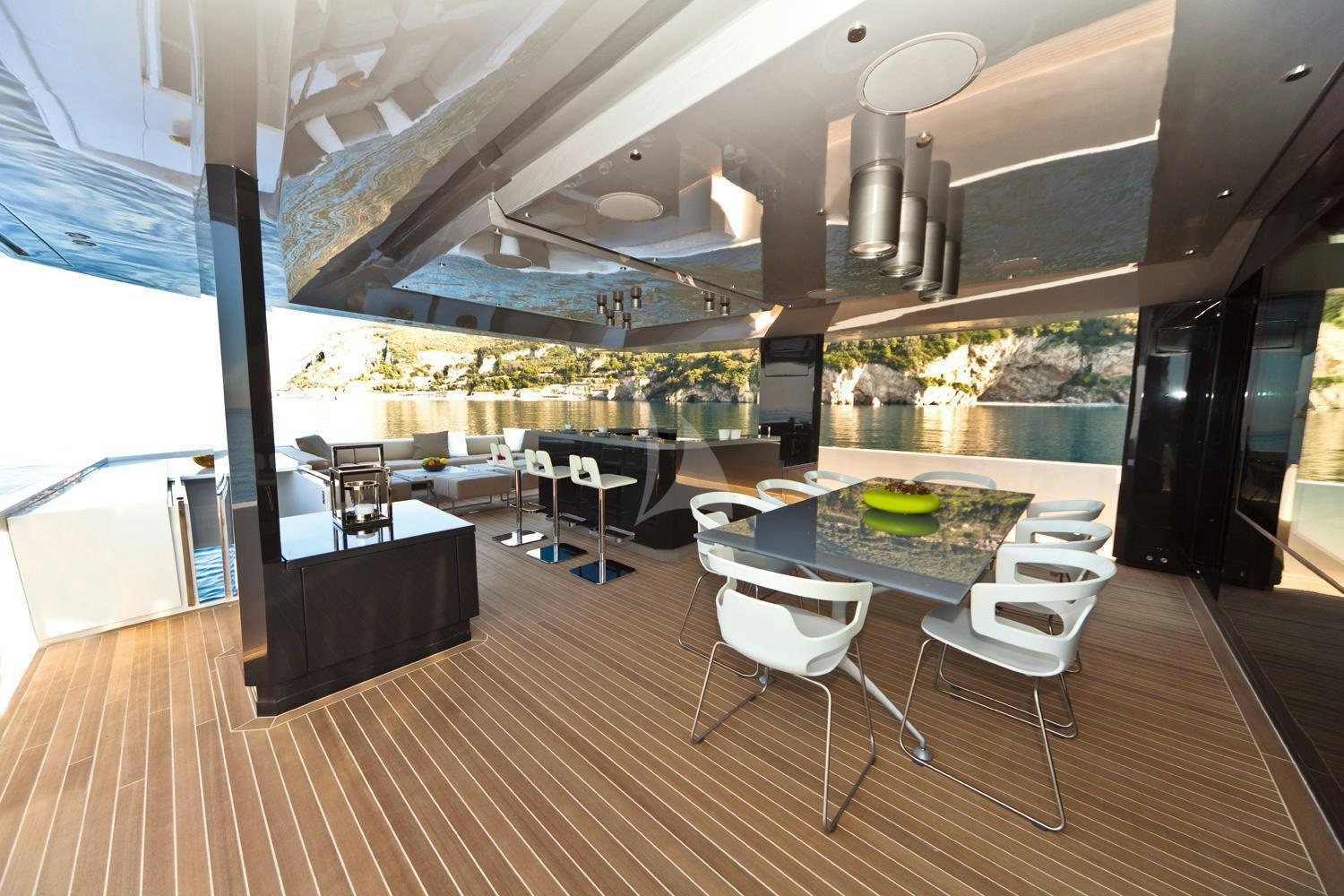 a large room with a table and chairs and a large window aboard SUN Yacht for Charter