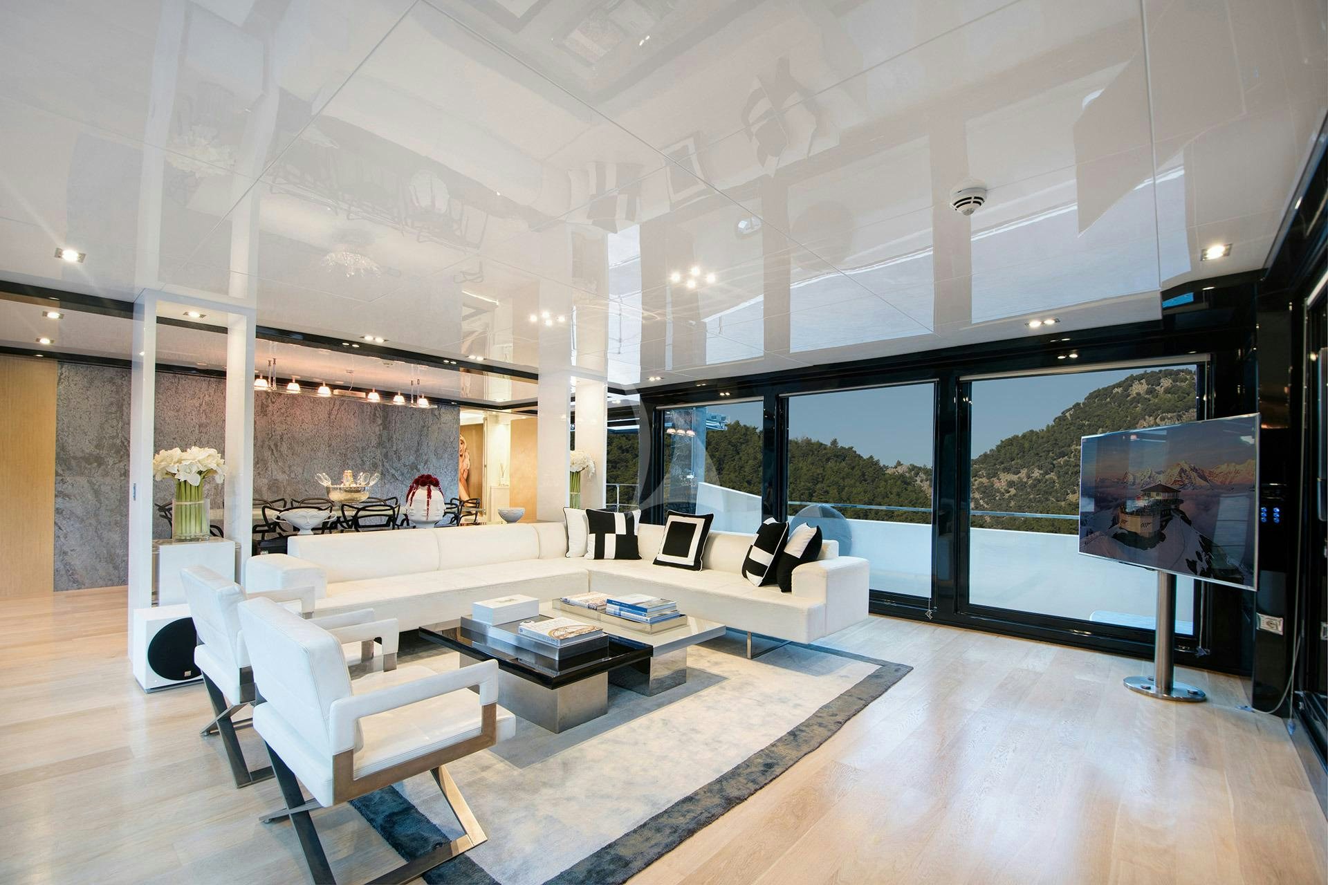 a room with a large window and a large table with chairs aboard SUN Yacht for Charter