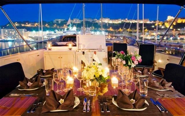 a table with candles and flowers on it aboard OBSESSION Yacht for Charter