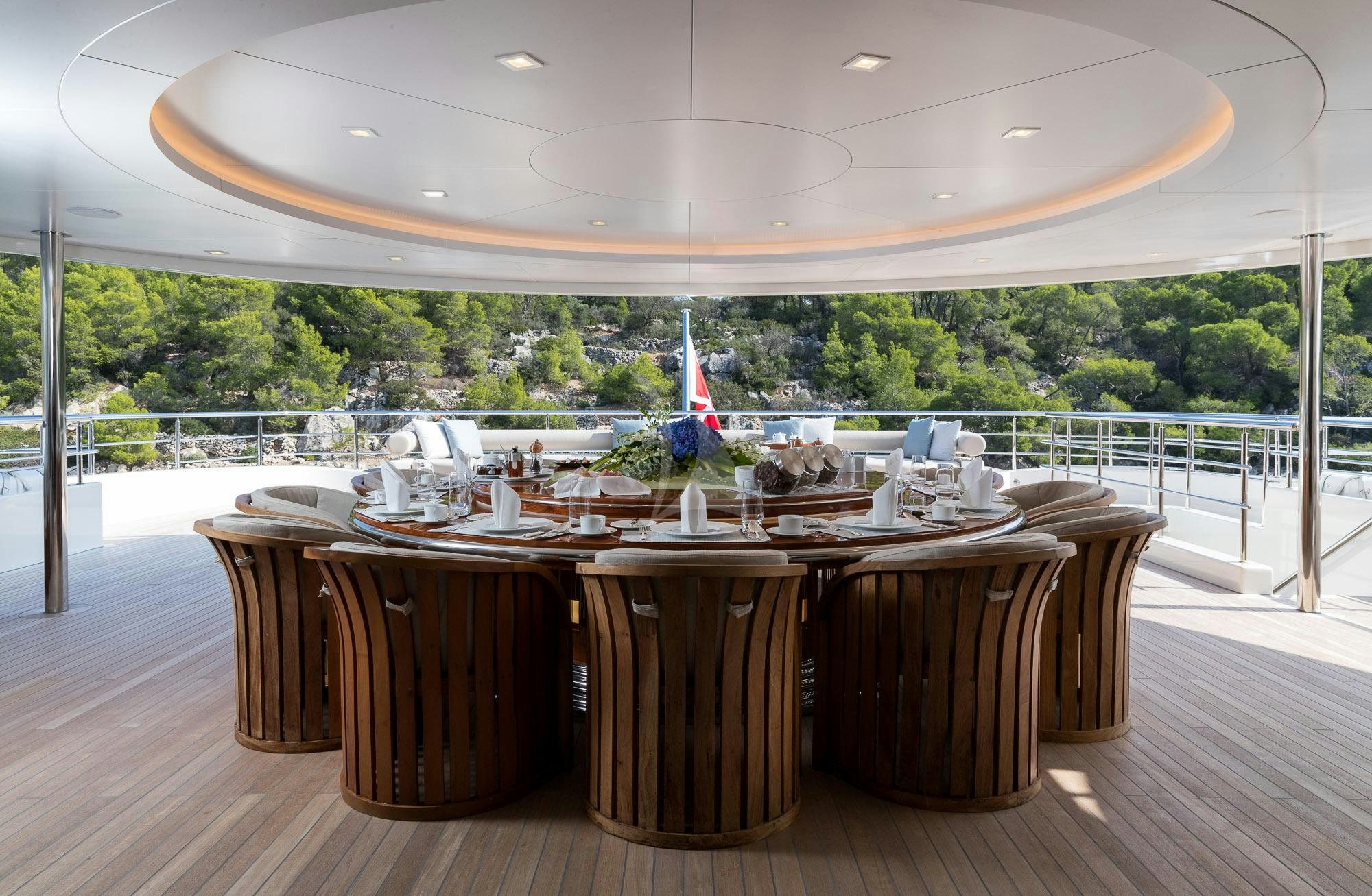 a table with chairs and a large window overlooking a forest aboard O'PTASIA Yacht for Sale