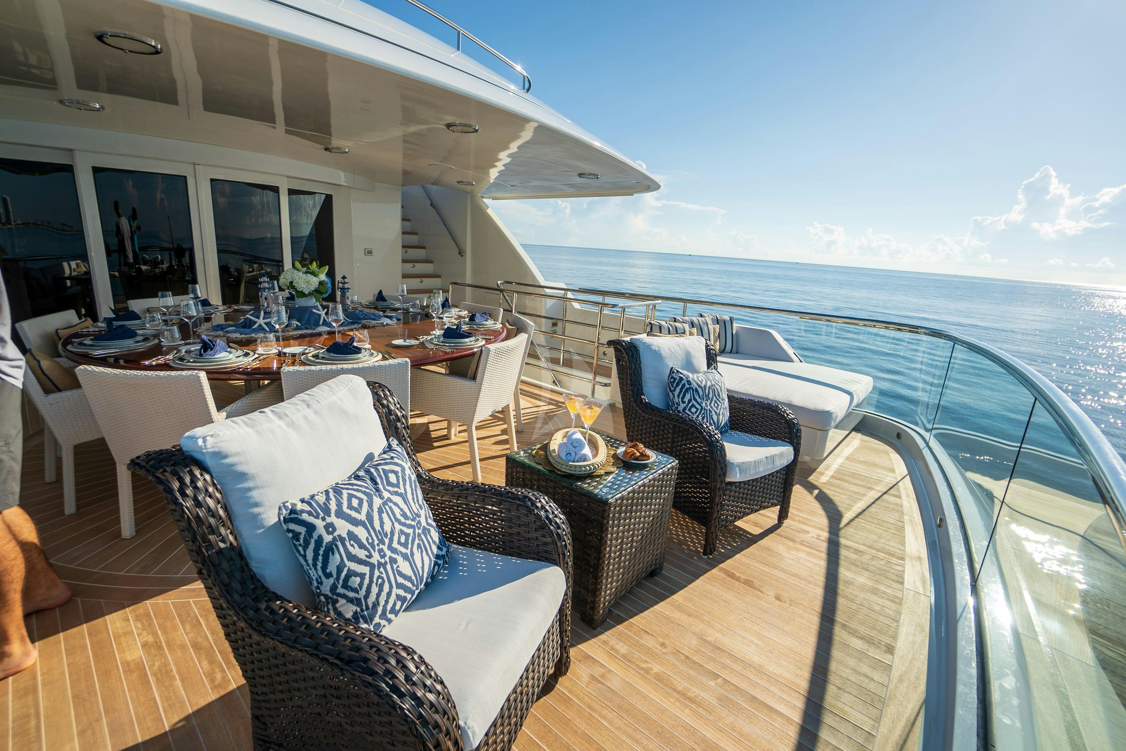 a deck with a large body of water and a large boat in the background aboard CROSSED SABRE Yacht for Charter