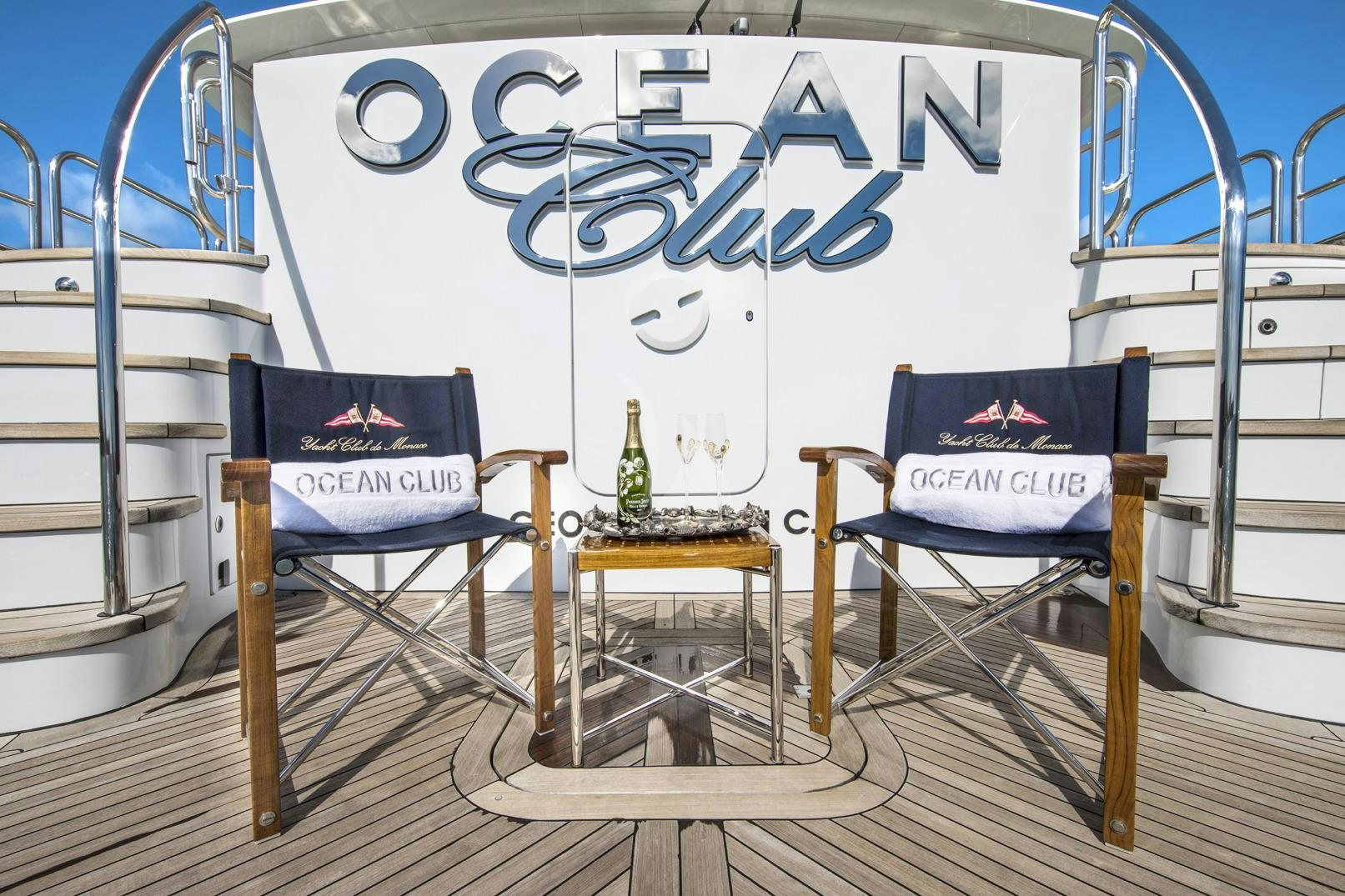 a glass display case with a bottle and a chair on it aboard OCEAN CLUB Yacht for Charter