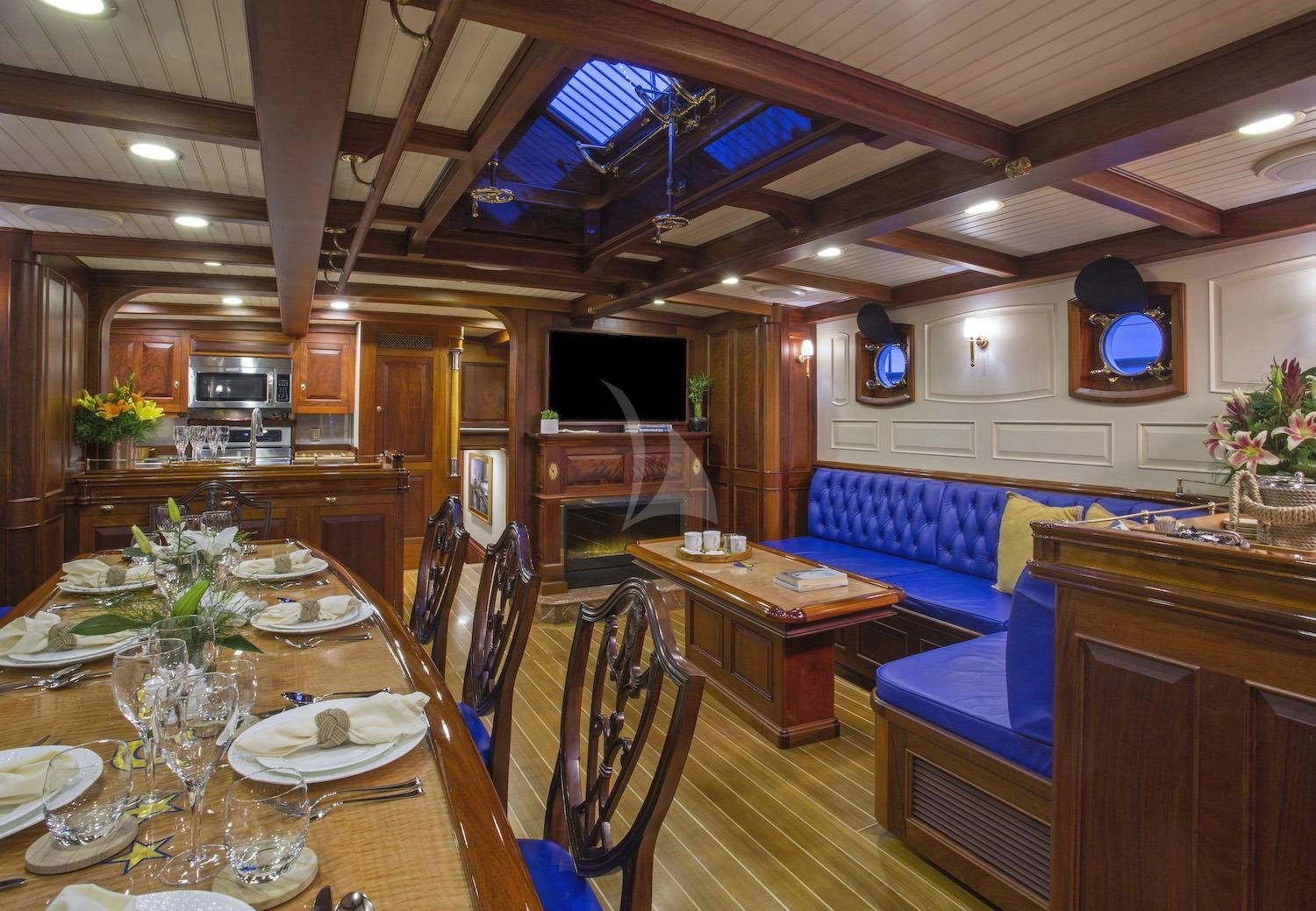 a dining room with a large open kitchen and living room aboard COLUMBIA Yacht for Charter