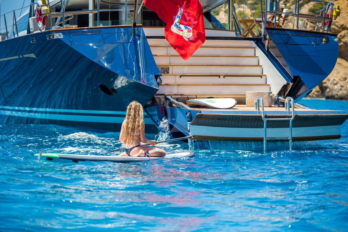 a person on a surfboard in the water aboard Q Yacht for Charter