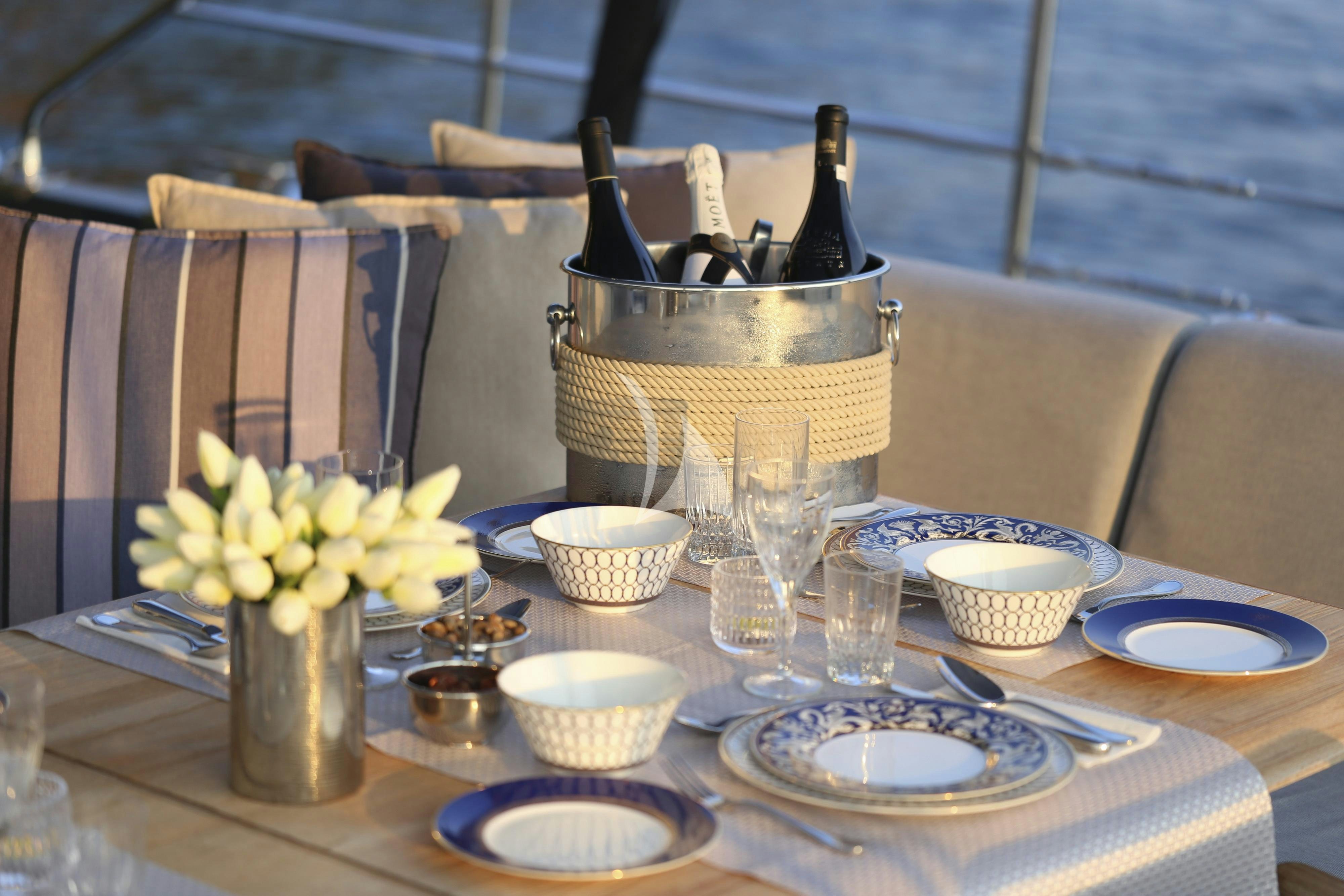 a table with plates and cups on it aboard MUSIC Yacht for Charter