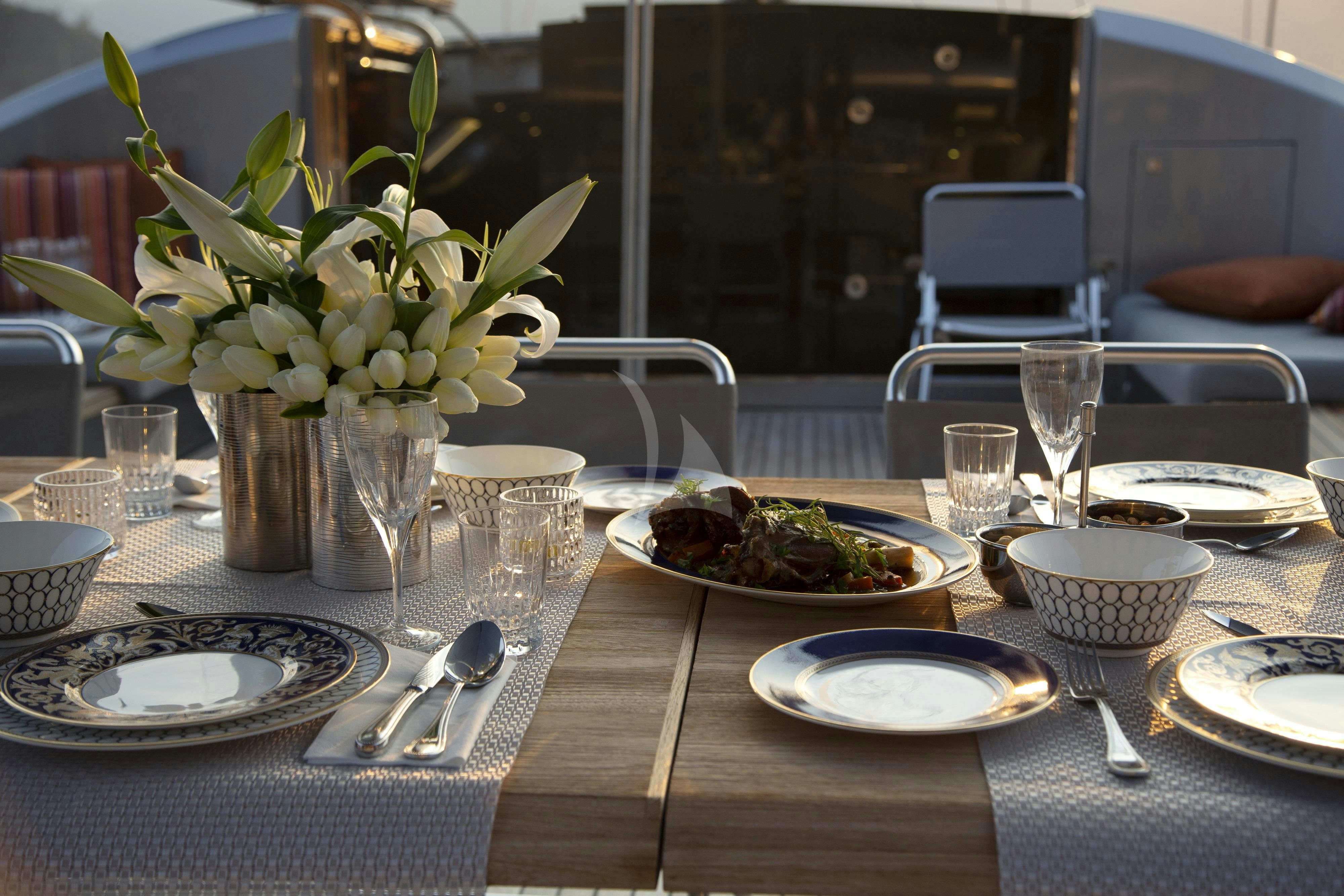 a table with plates and glasses aboard MUSIC Yacht for Charter