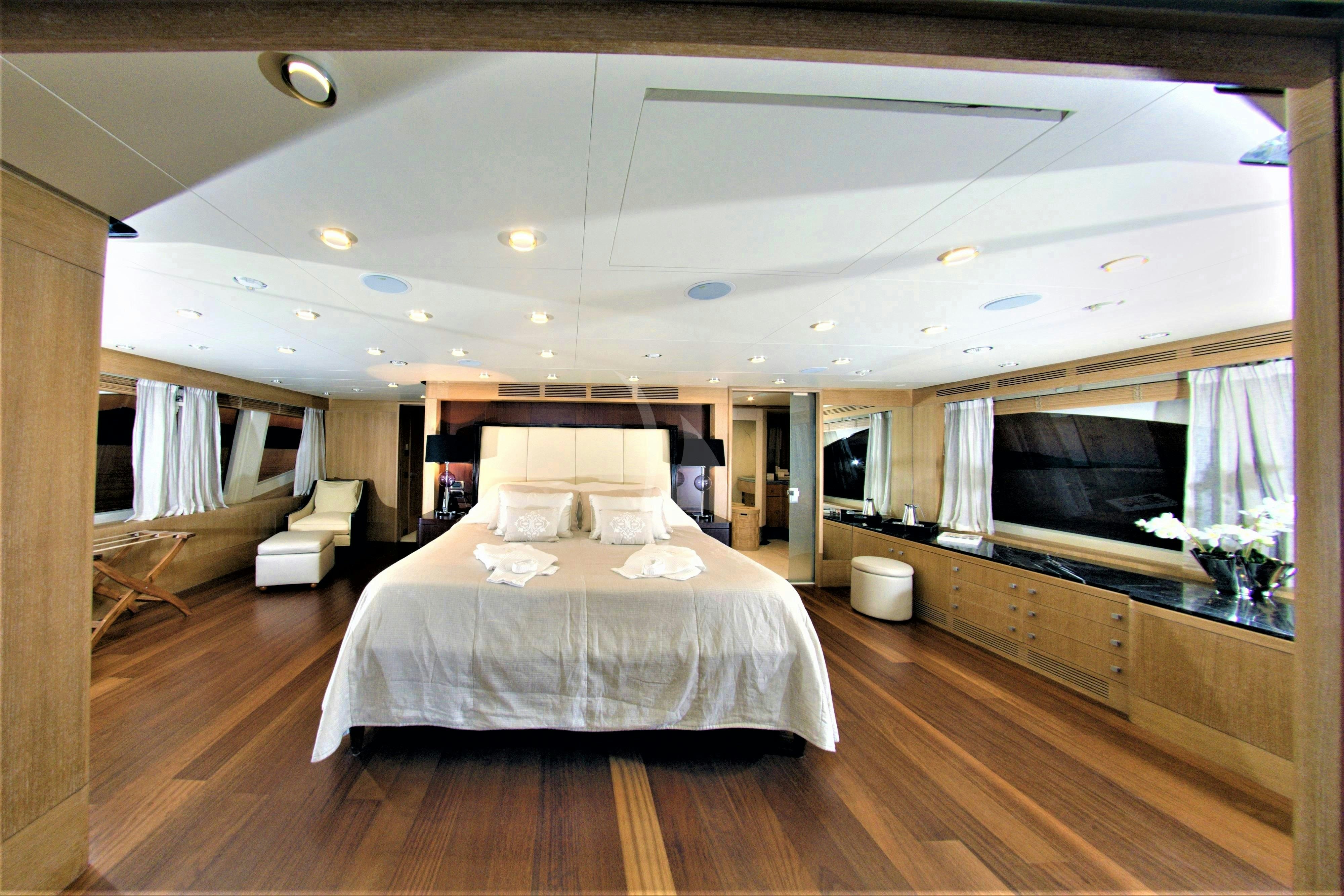a room with a bed and a television aboard GRANDE AMORE Yacht for Charter