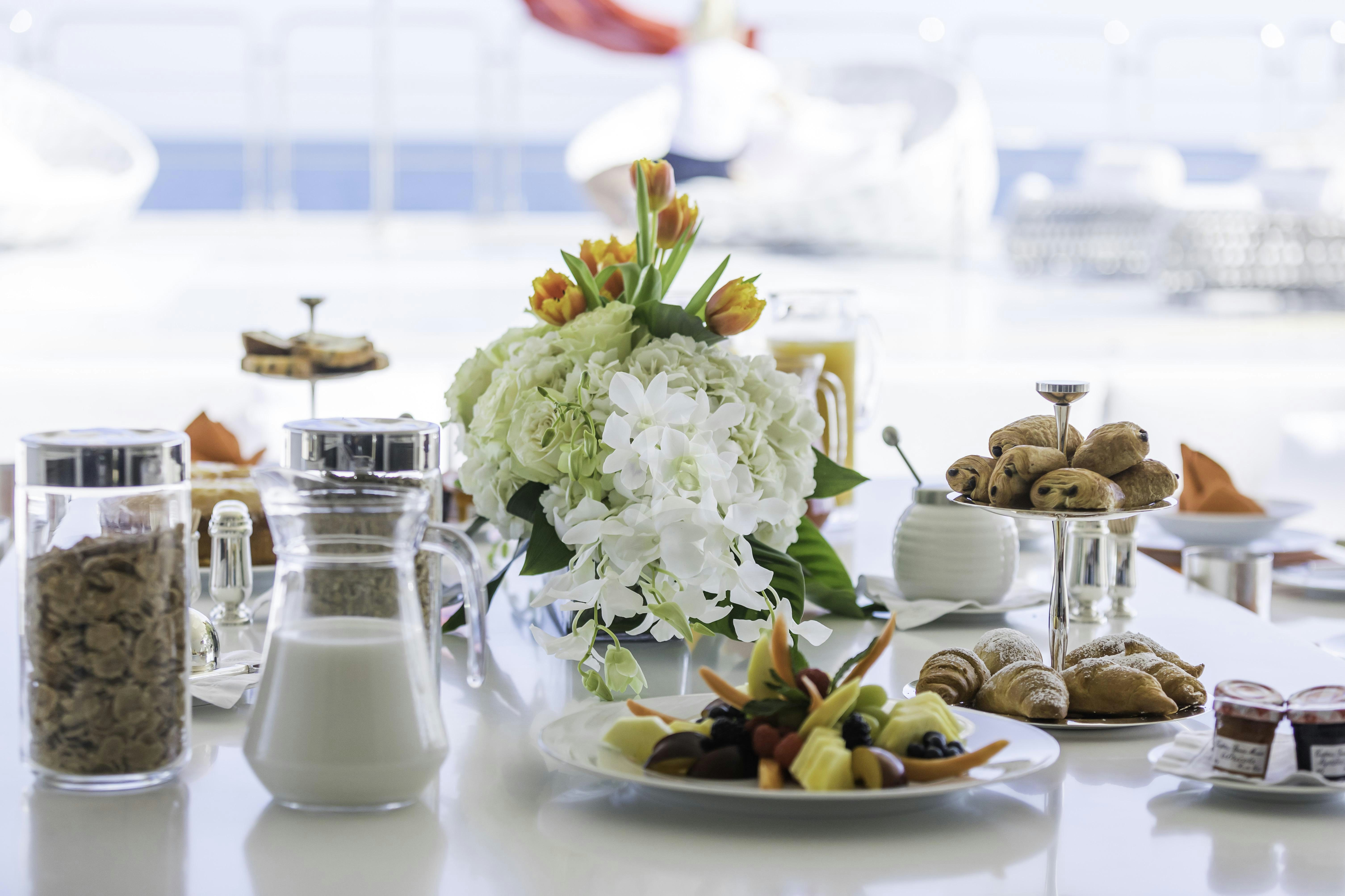 a table with food and a vase of flowers aboard VICKY Yacht for Charter