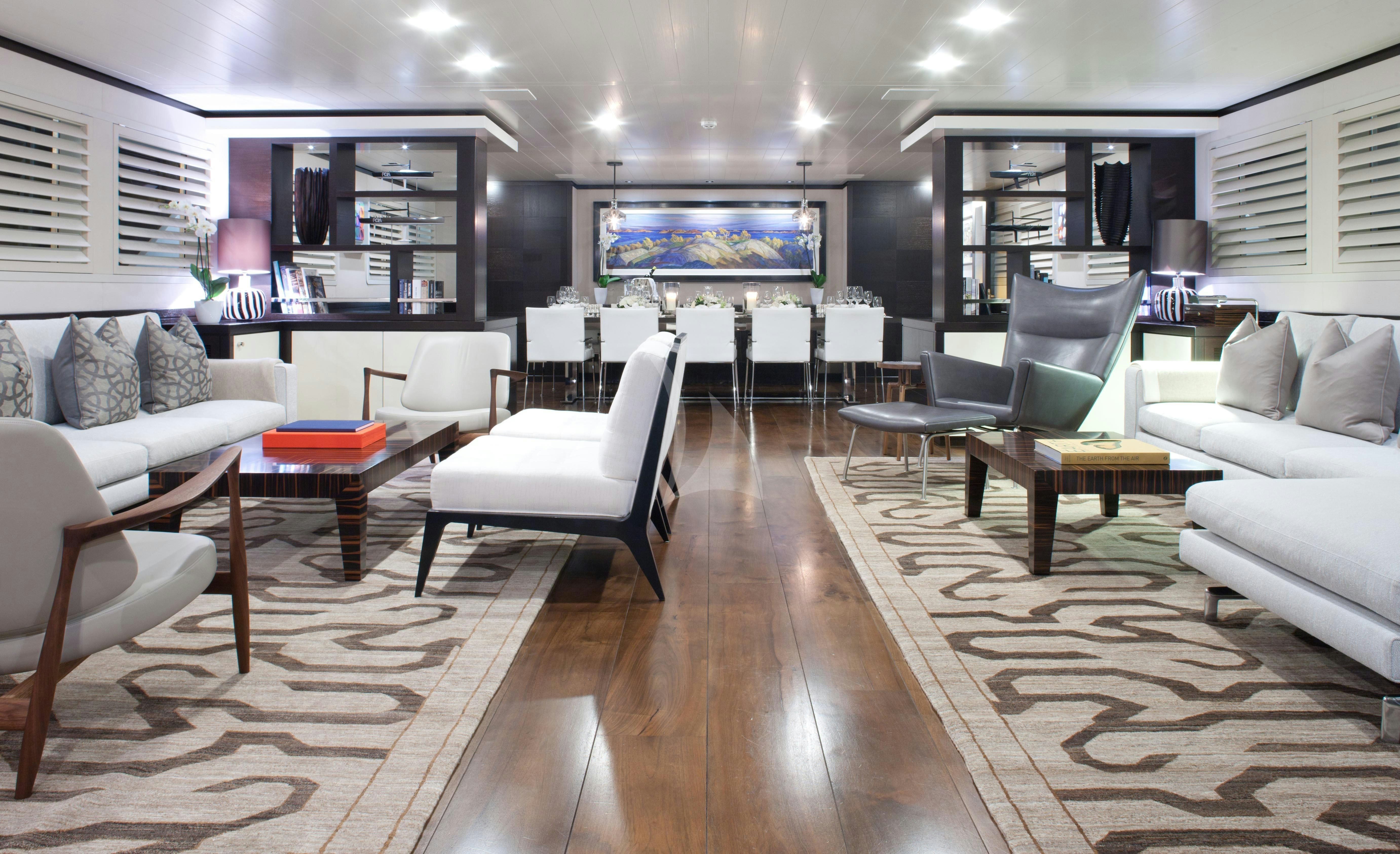 a room with a wood floor and white couches aboard MIRAGE Yacht for Charter