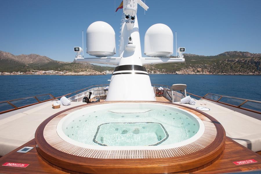 a large white ship with a large round pool in the middle of a body of water aboard MIRAGE Yacht for Charter