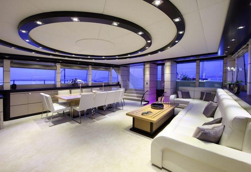 a room with white chairs and a table with a large window aboard PERLA DEL MARE Yacht for Charter