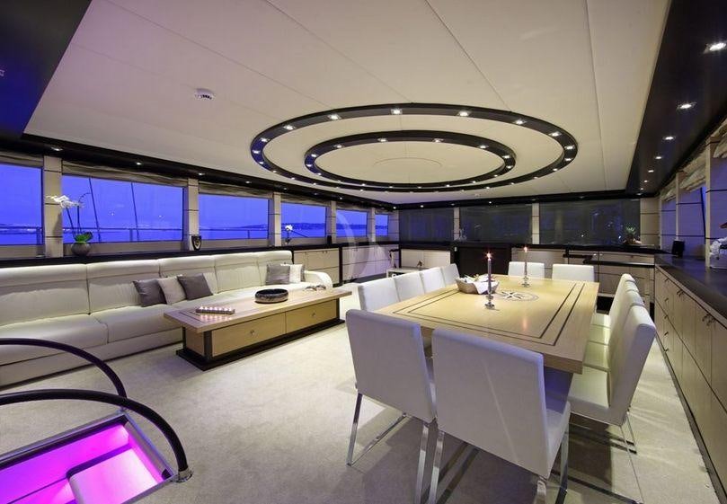 a room with white chairs and a round table with white chairs aboard PERLA DEL MARE Yacht for Charter