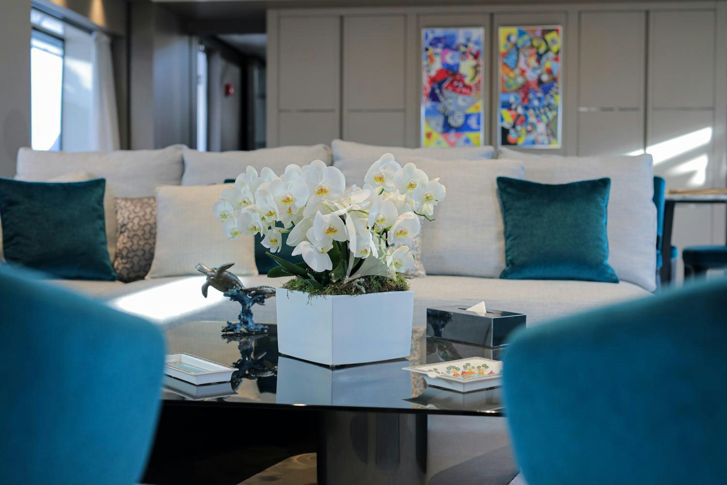 a white couch with blue pillows and flowers on it aboard JAG'B Yacht for Charter