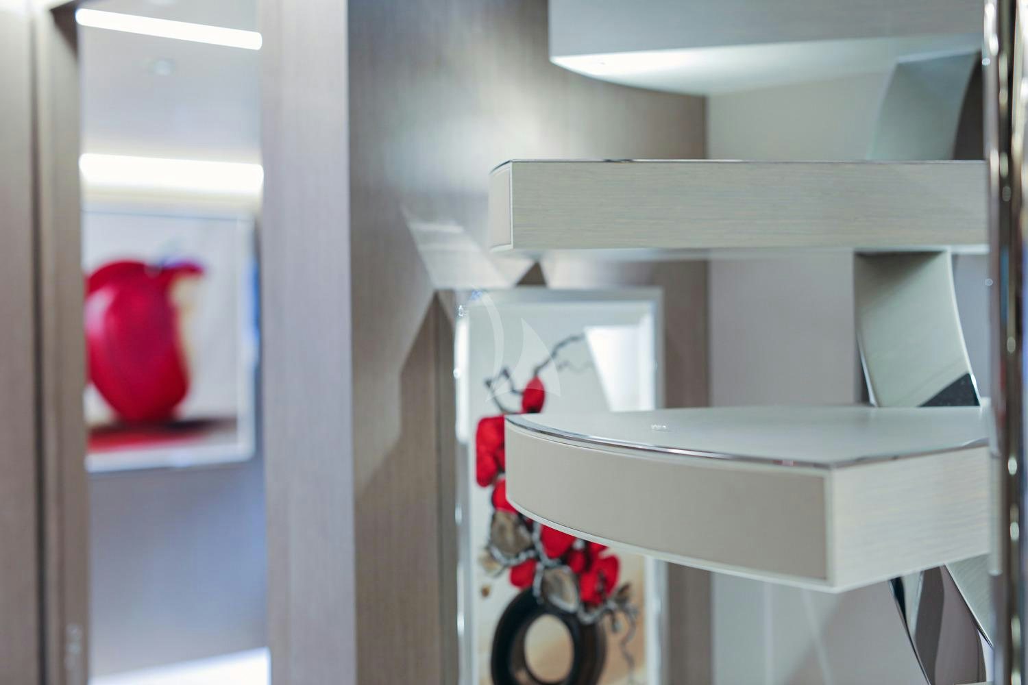 a red and white vase on a white shelf aboard JAG'B Yacht for Charter