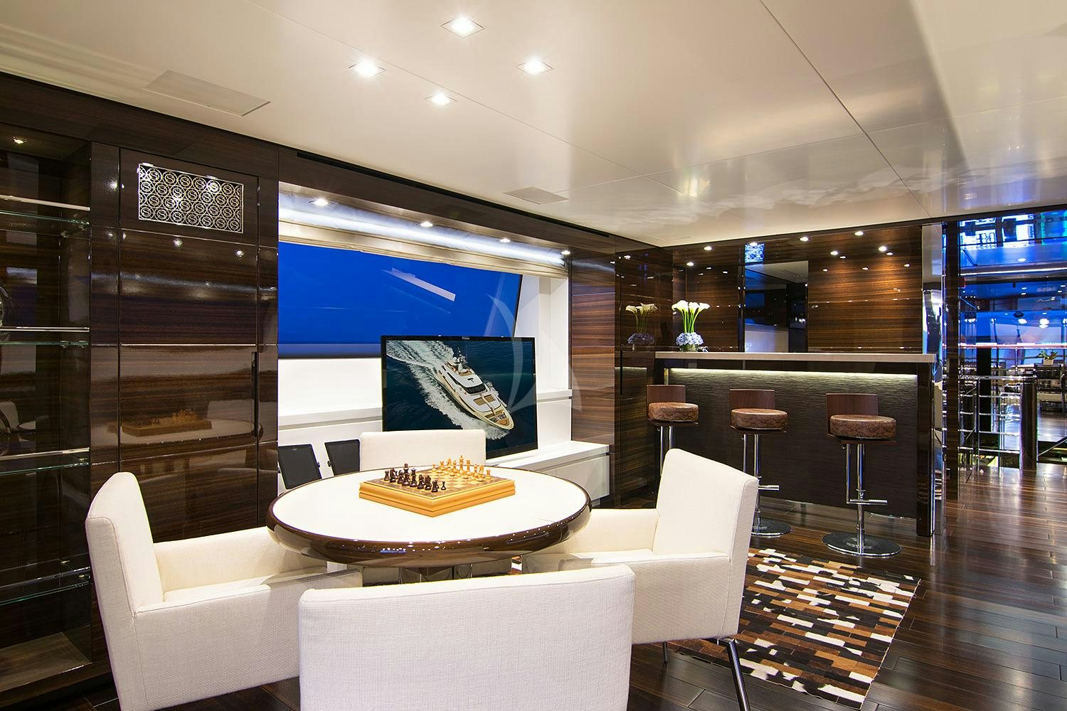 a room with a table chairs and a tv aboard SOURAYA Yacht for Charter