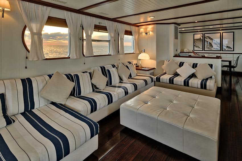 a room with a bed and a couch aboard PERSUADER Yacht for Charter