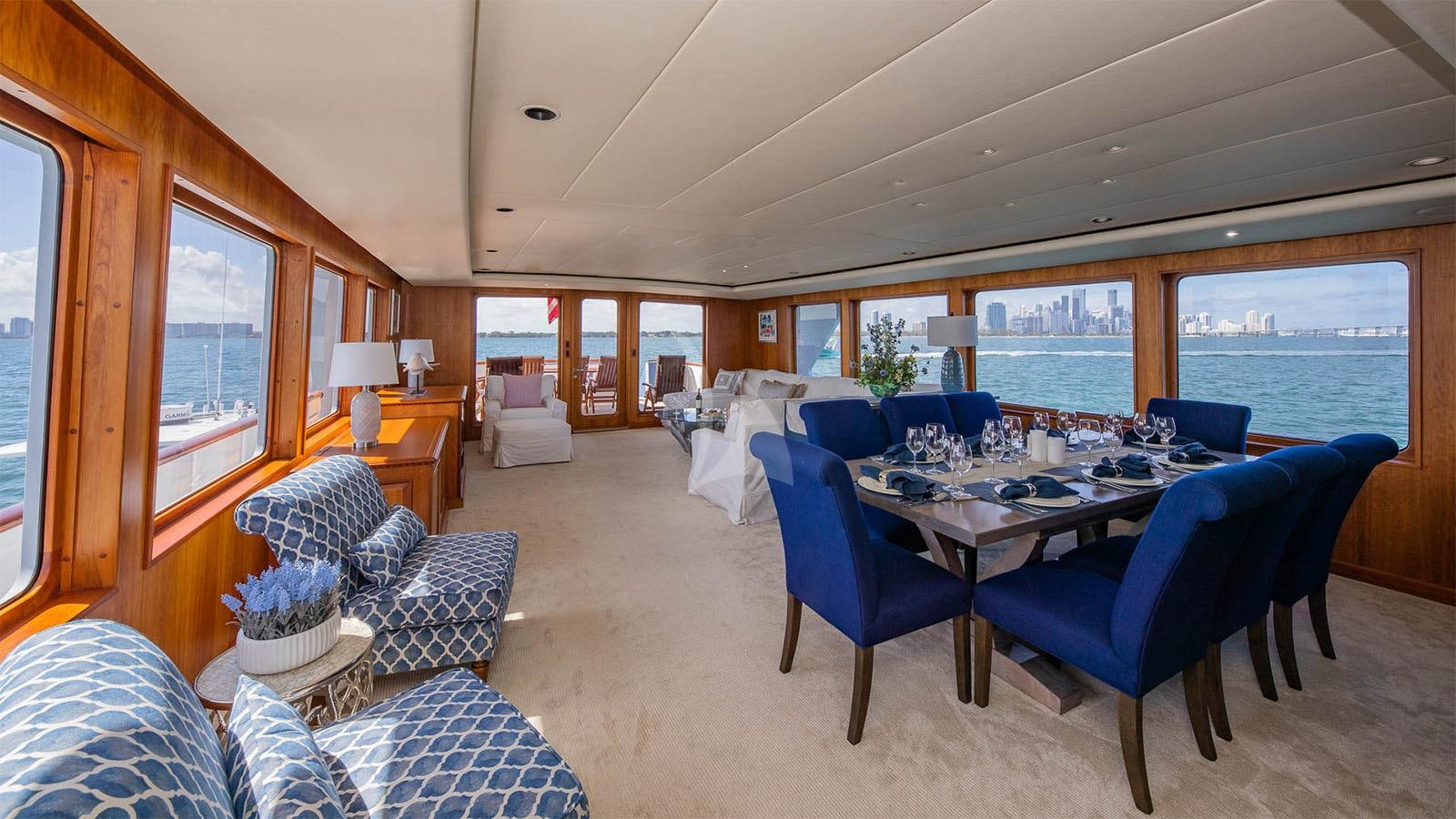 a large living room with a large blue table and chairs aboard SILVER SEAS Yacht for Charter