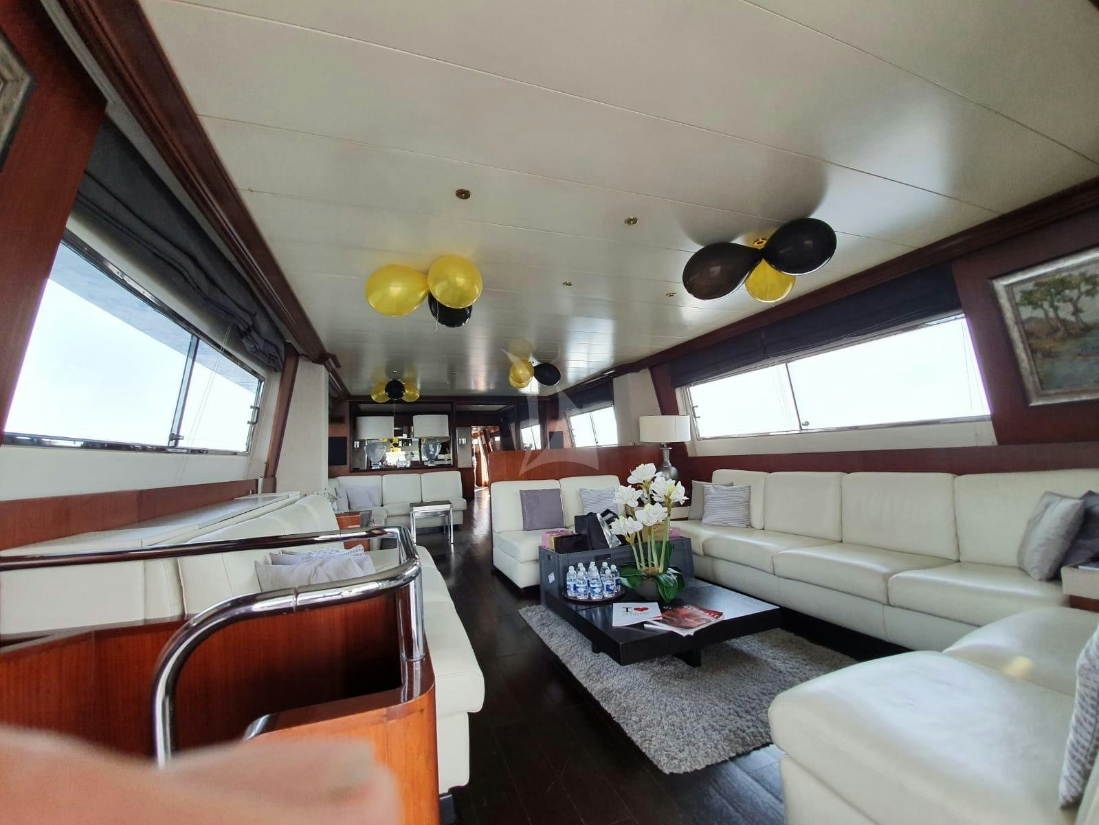 a room with a couch and a table with flowers in it aboard QUEEN SOUTH Yacht for Charter