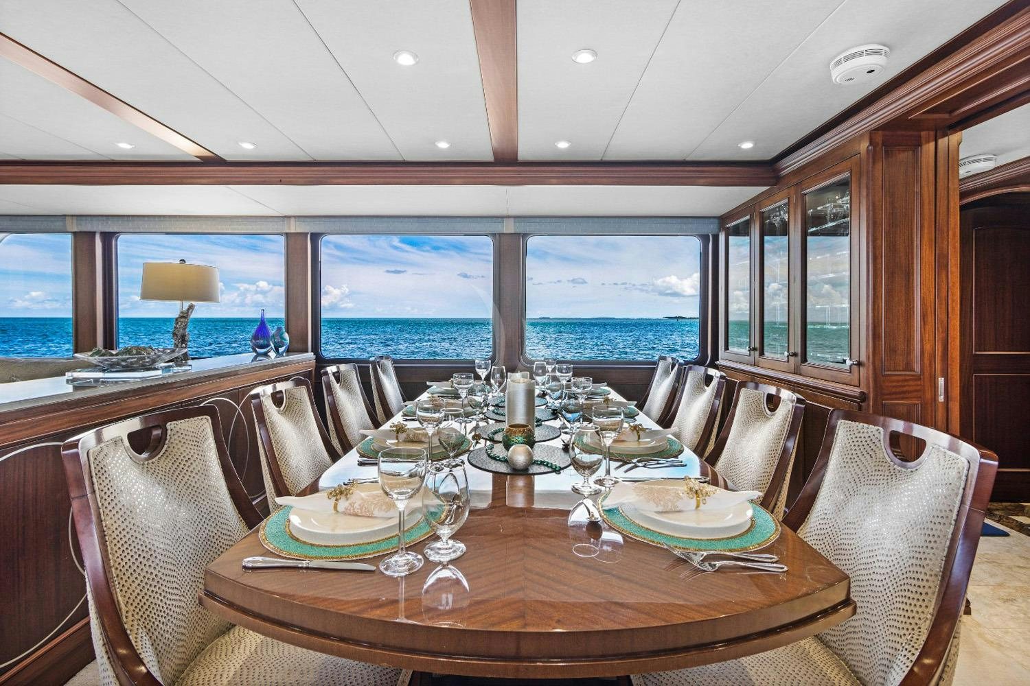 a dining table with a view of the ocean aboard GITANA Yacht for Charter