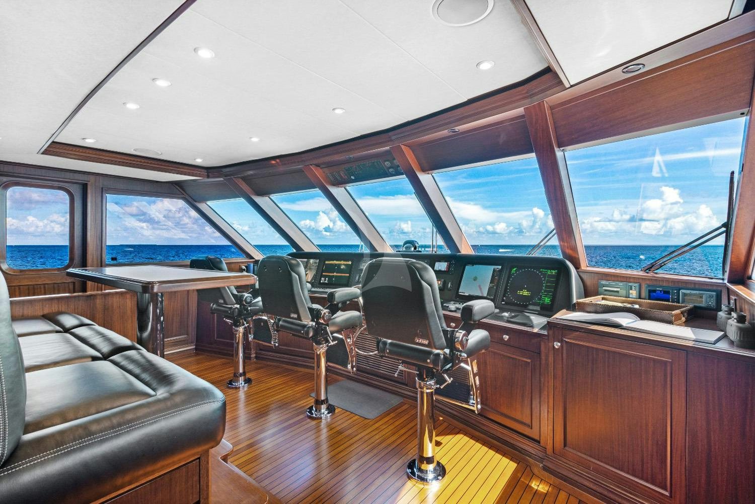inside of a vehicle with a desk and chairs and a large window aboard GITANA Yacht for Charter