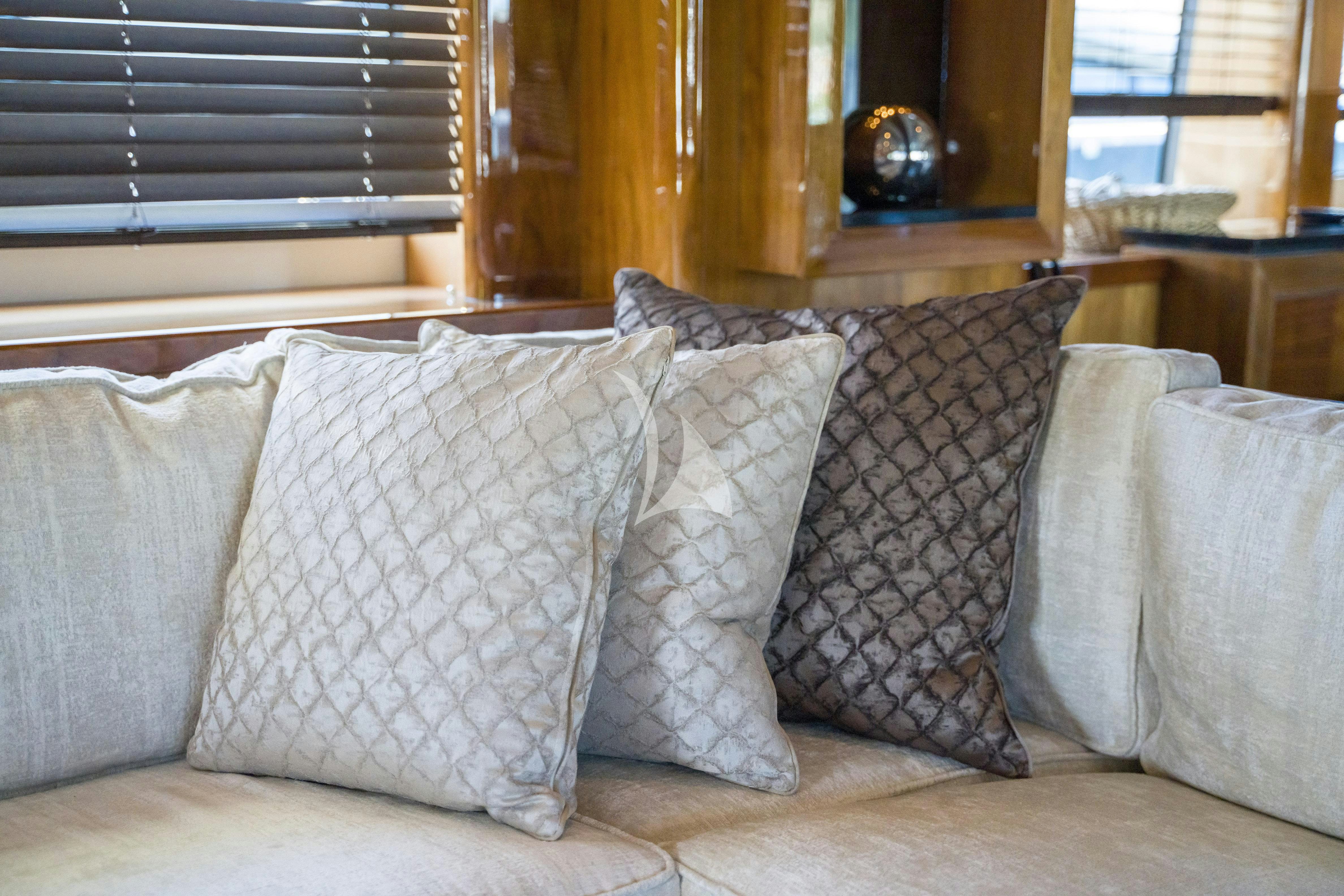 a couch with pillows aboard ARAGO Yacht for Charter