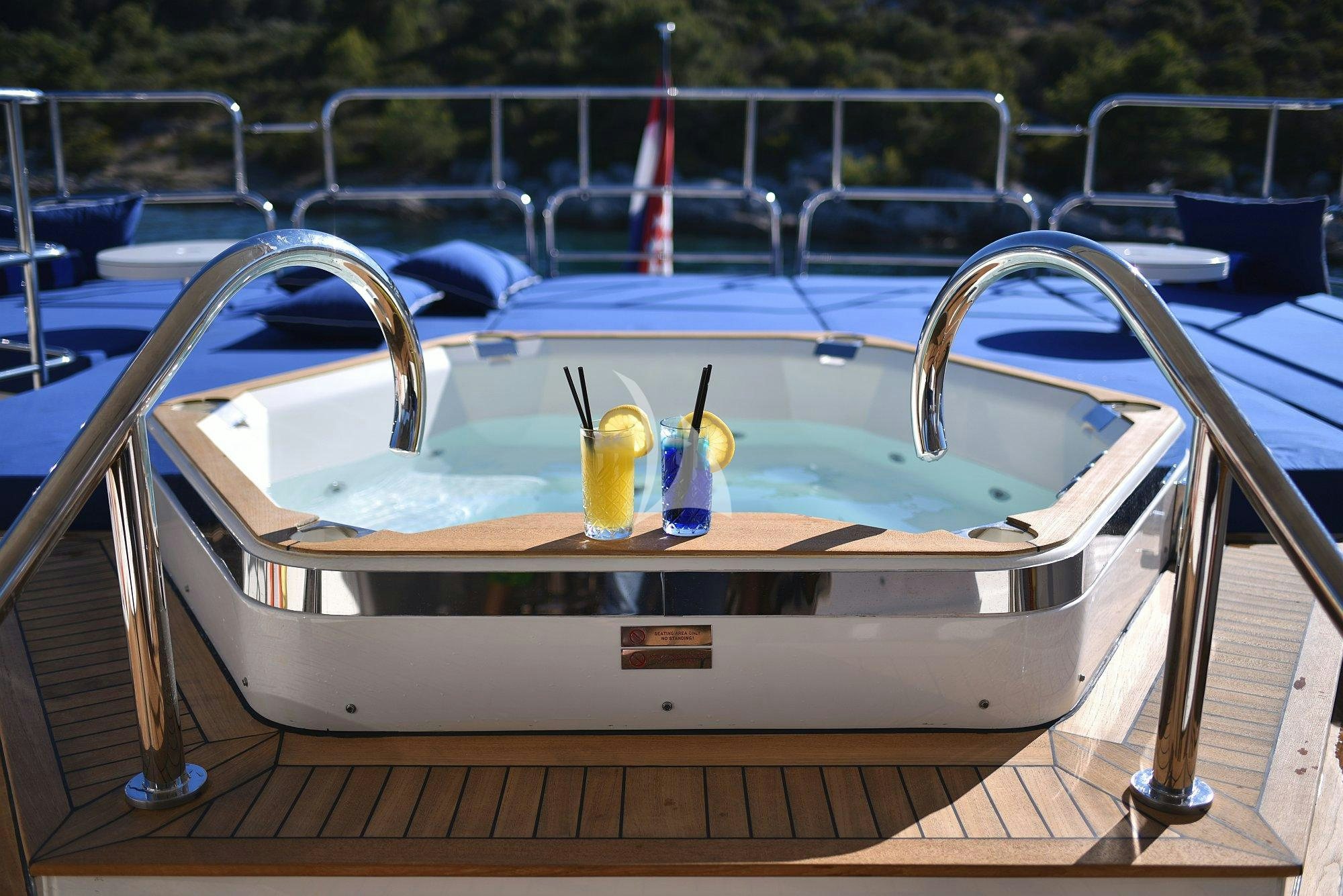 a table with drinks and a straw on a deck aboard ARAGO Yacht for Charter