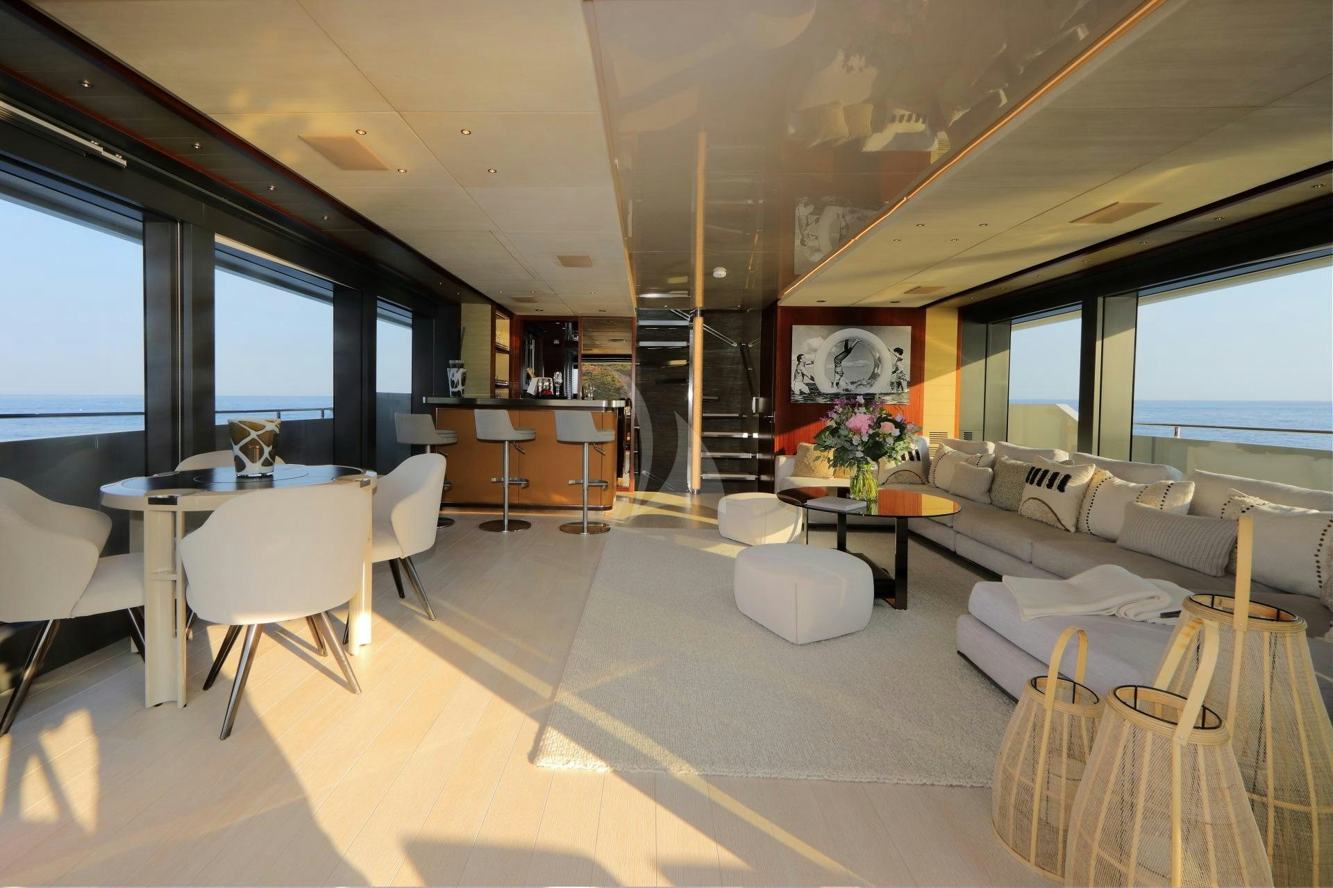 a room with tables and chairs aboard X Yacht for Charter