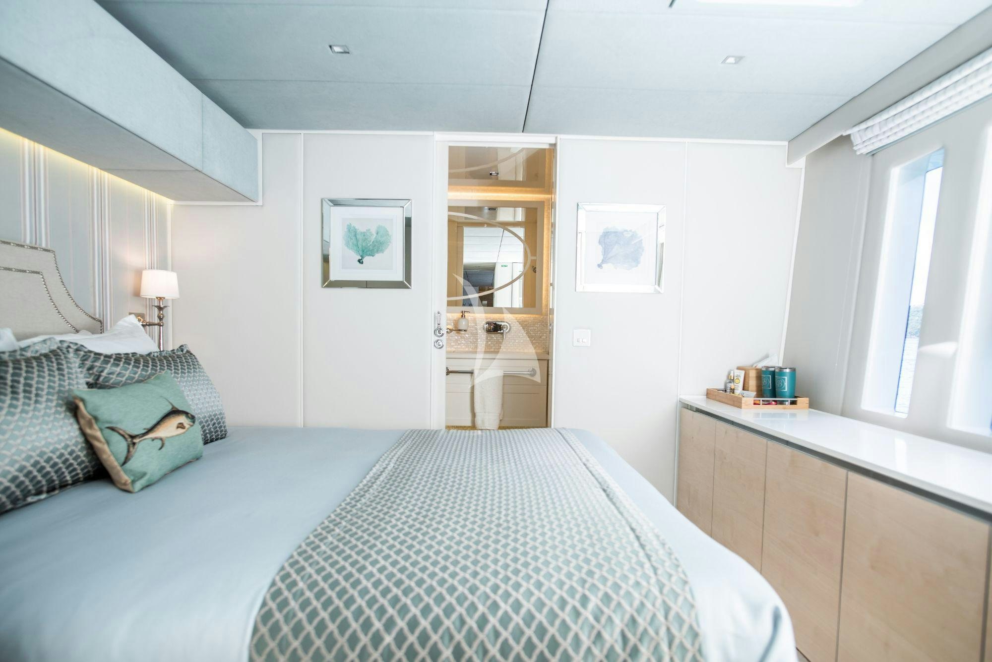 a bedroom with a bed and a mirror aboard BUNDALONG Yacht for Charter