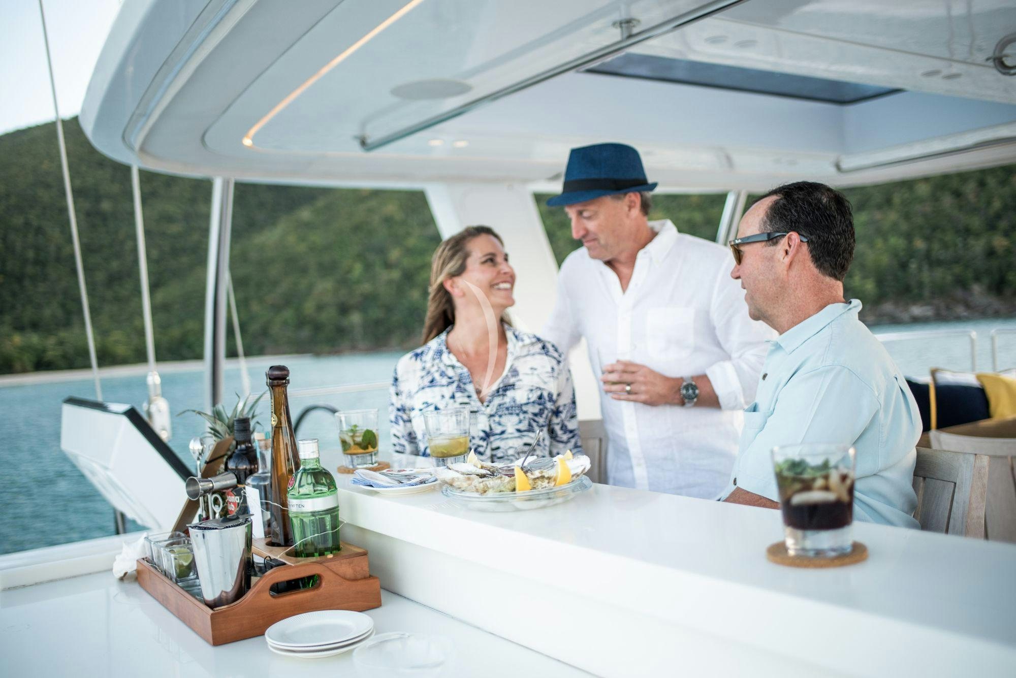 a group of people sitting at a table with food and drinks aboard BUNDALONG Yacht for Charter
