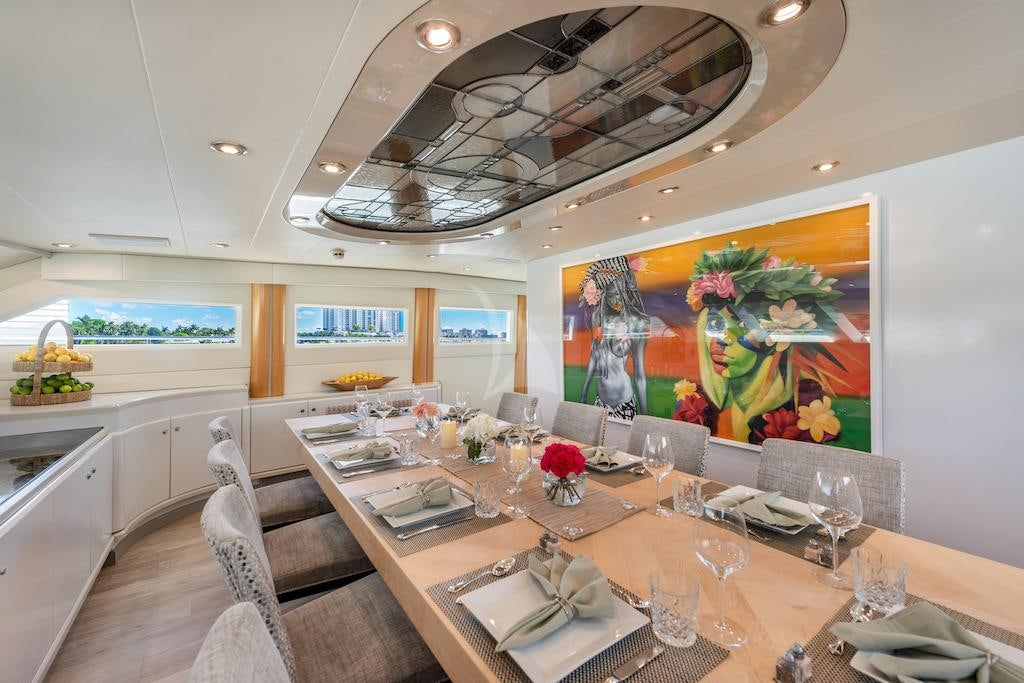 a large dining table with a large painting above it aboard SURINA Yacht for Charter