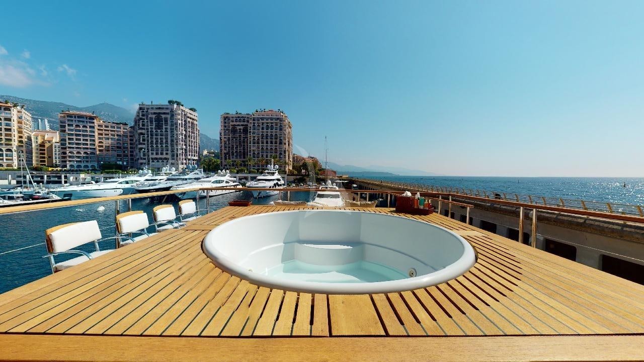 a deck with a pool and a city in the background aboard LA PELLEGRINA 1 Yacht for Charter