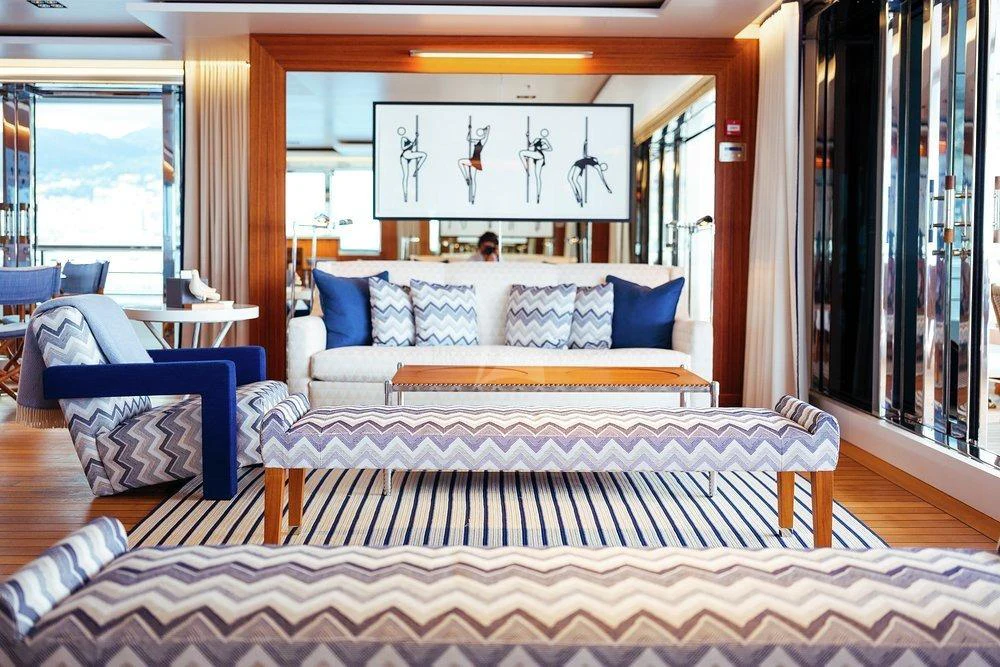 a bedroom with a bed and a chair aboard PLANET NINE Yacht for Charter