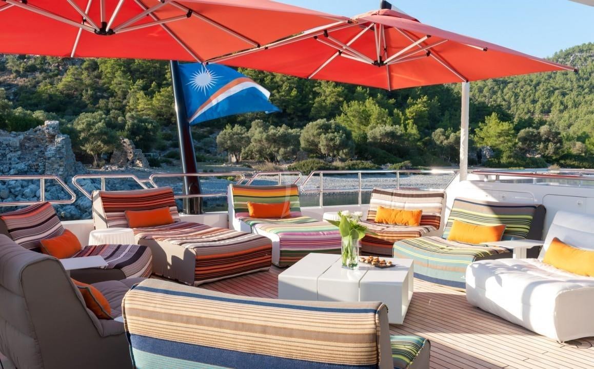 a pool with lounge chairs and umbrellas aboard UNEXPECTED Yacht for Charter