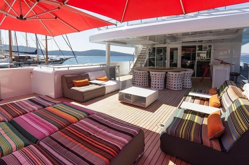 a boat with a couch and a table on the deck aboard UNEXPECTED Yacht for Charter