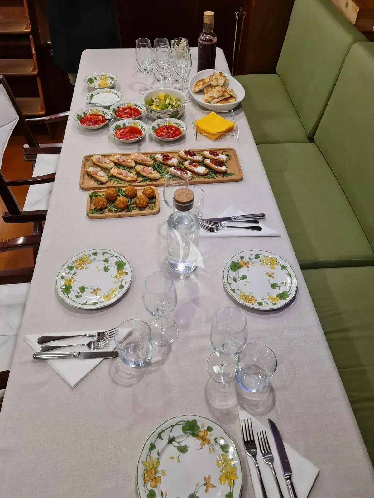 a table with many plates of food and glasses on it aboard QUARTA SANTA MARIA Yacht for Sale