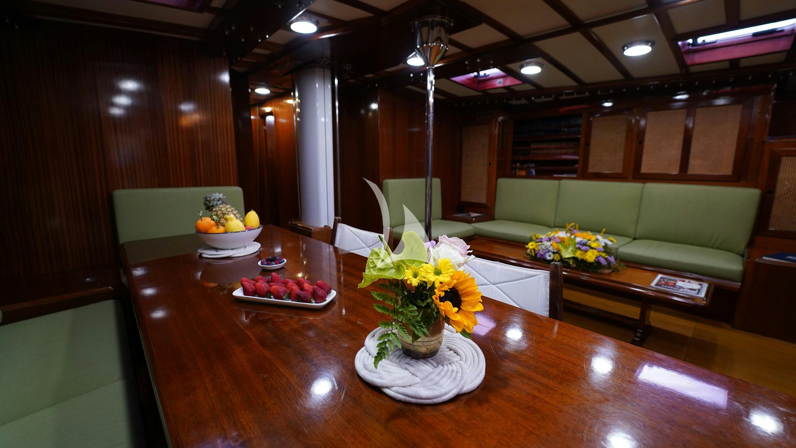 a room with a table and couches aboard QUARTA SANTA MARIA Yacht for Sale